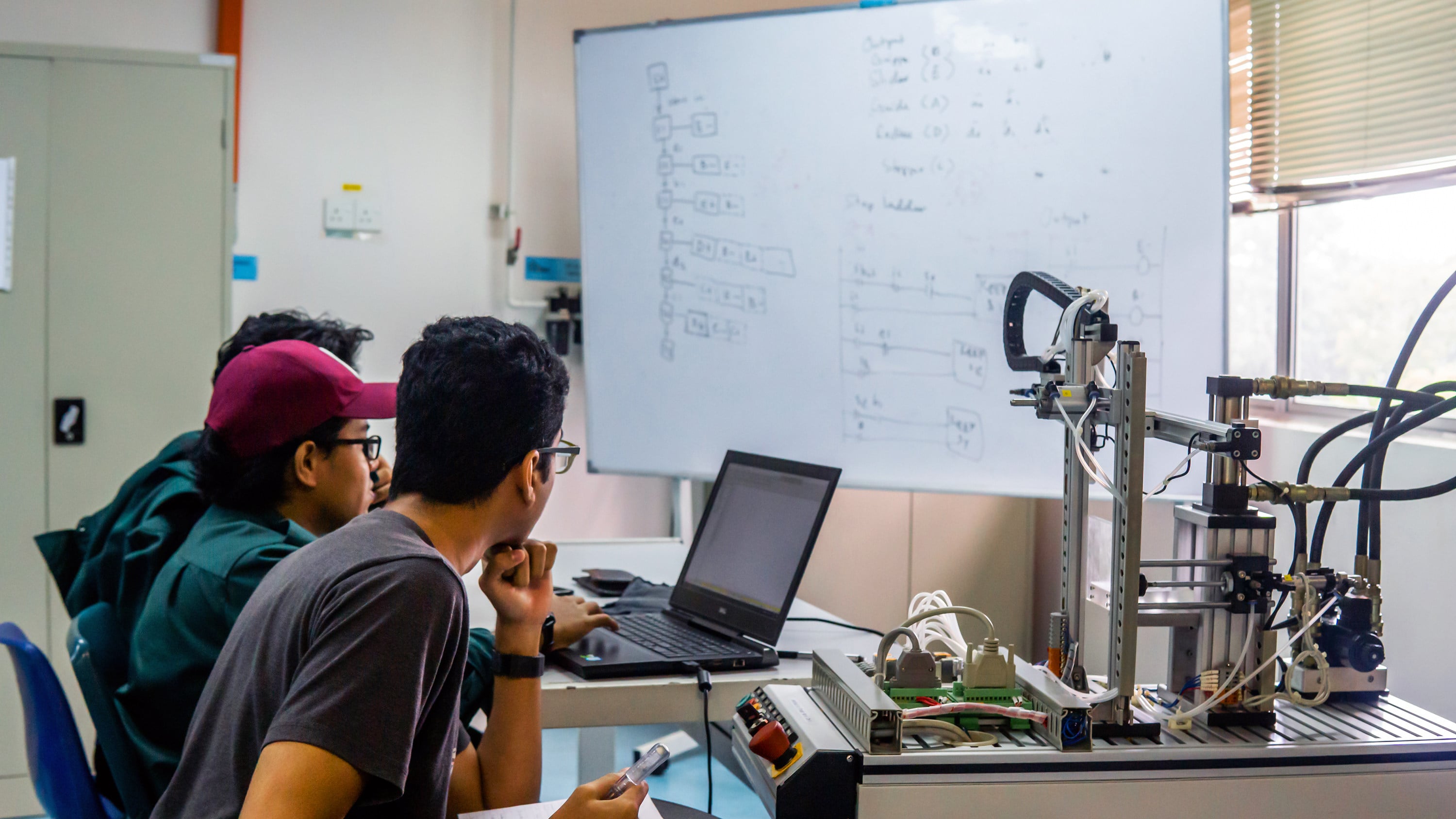 A group of engineering students discuss about an automation machine system in a laboratory in Bangi, Malaysia. Photo: TNS