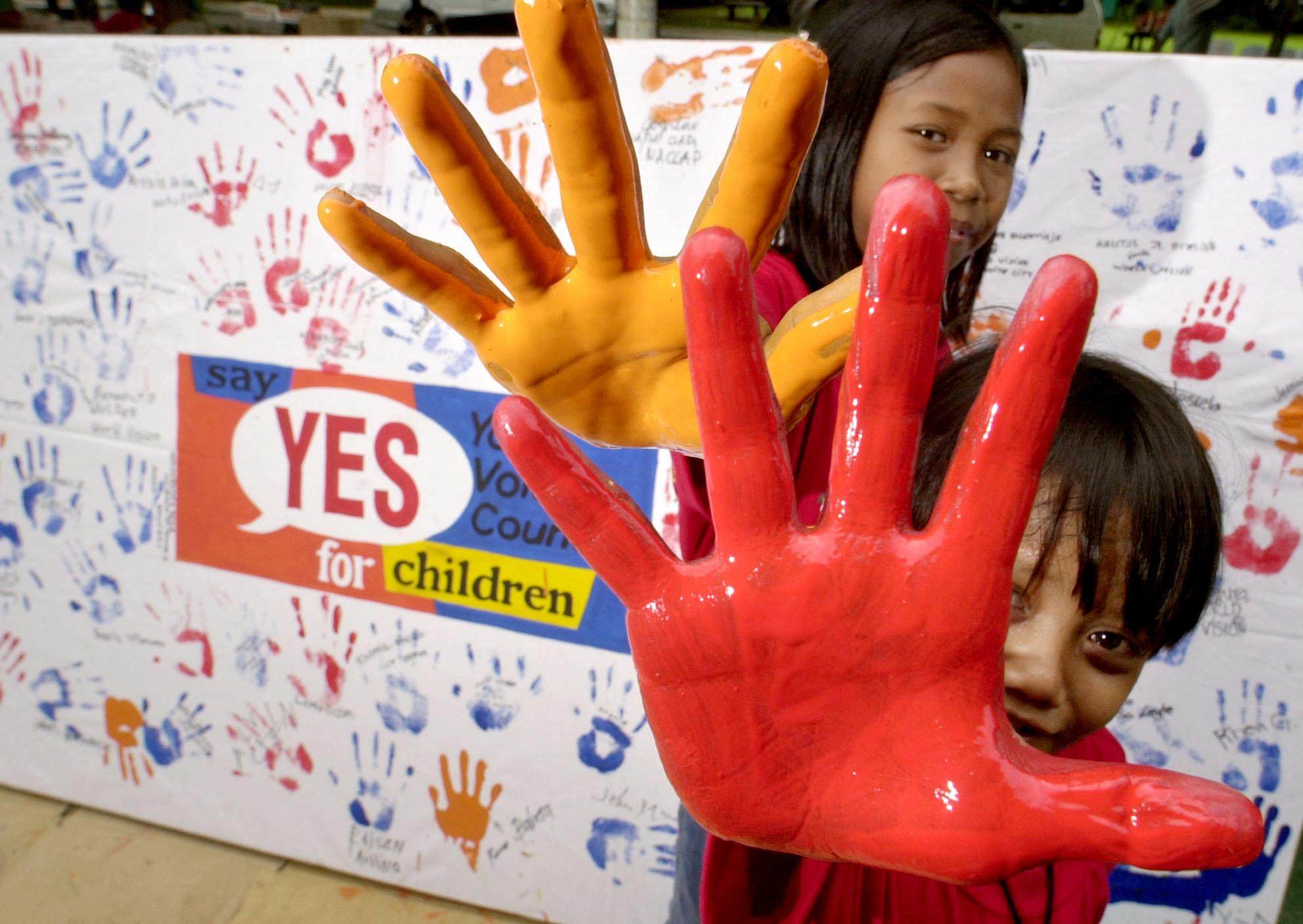 Two rescued Filipino child labourers show their painted hands before a ceremony to improve the lives of children held at the Malacanang presidential palace in Manila in 2001. Photo: AFP