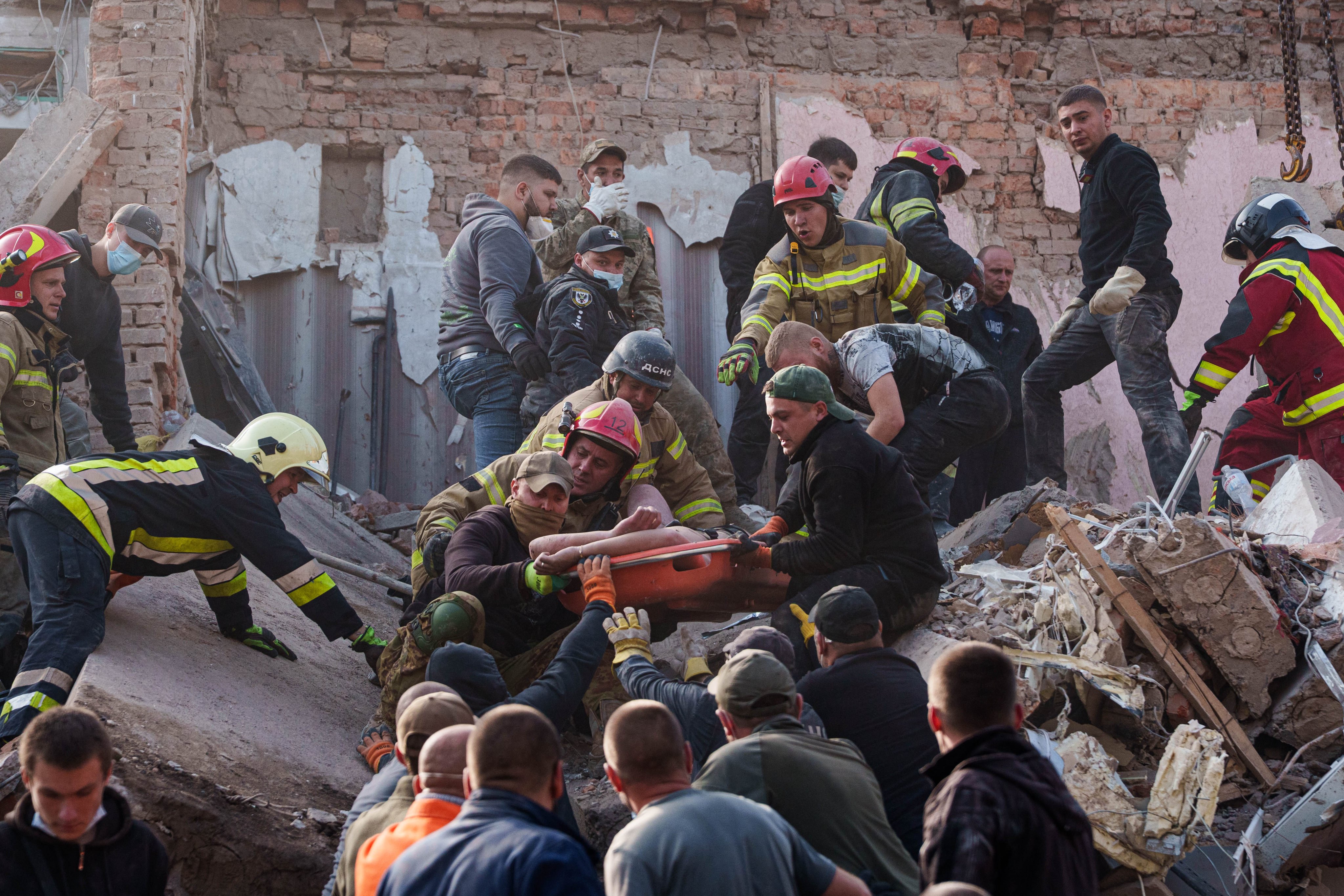 Rescuers and residents carry an injured man from a residential building destroyed by a Russian missile strike in Pryluky, Ukraine. Photo: AP