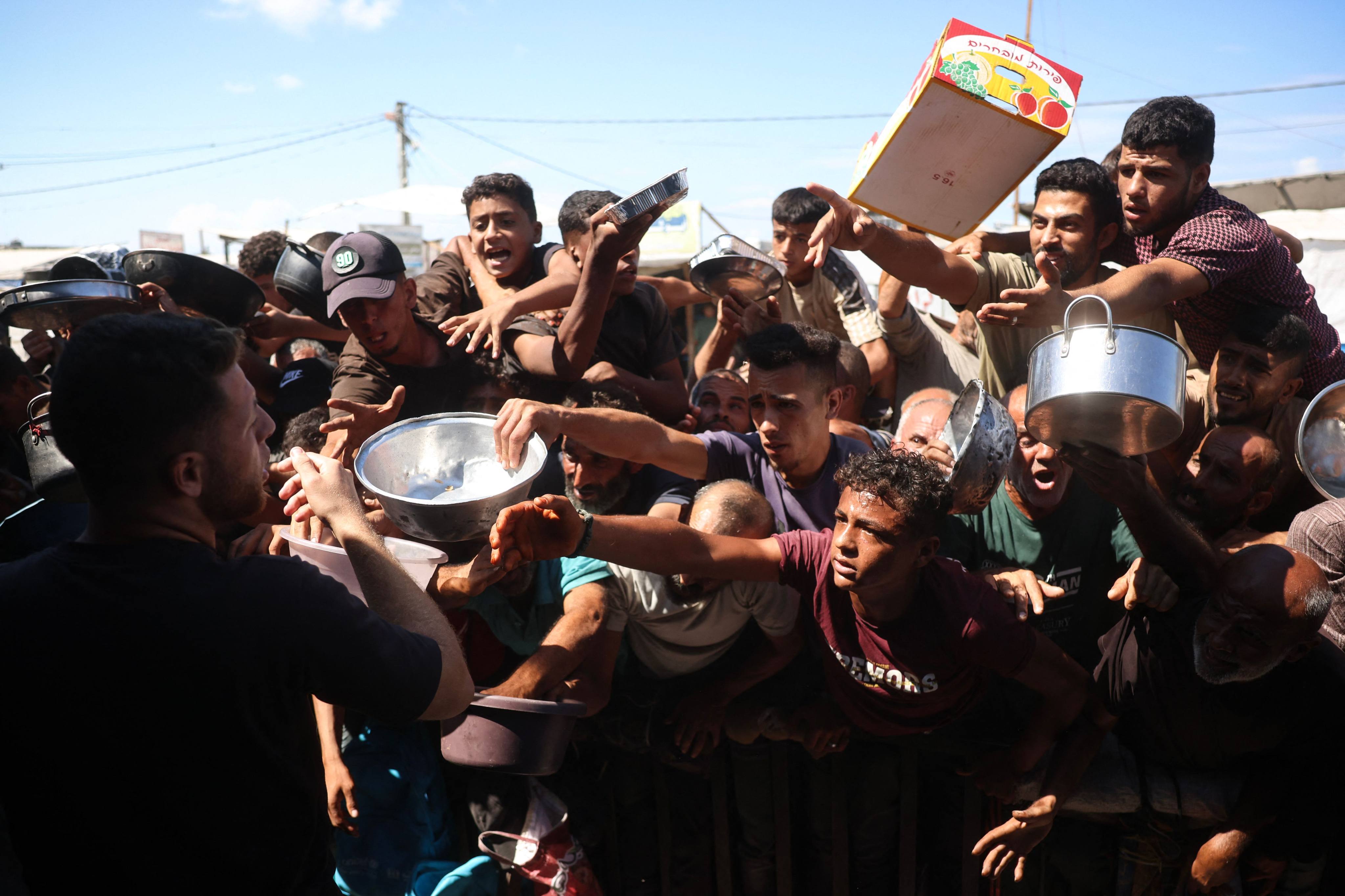 Displaced Palestinians wait to receive food at a charity kitchen in Khan Yunis, in the southern Gaza Strip on Monday. Photo: AFP