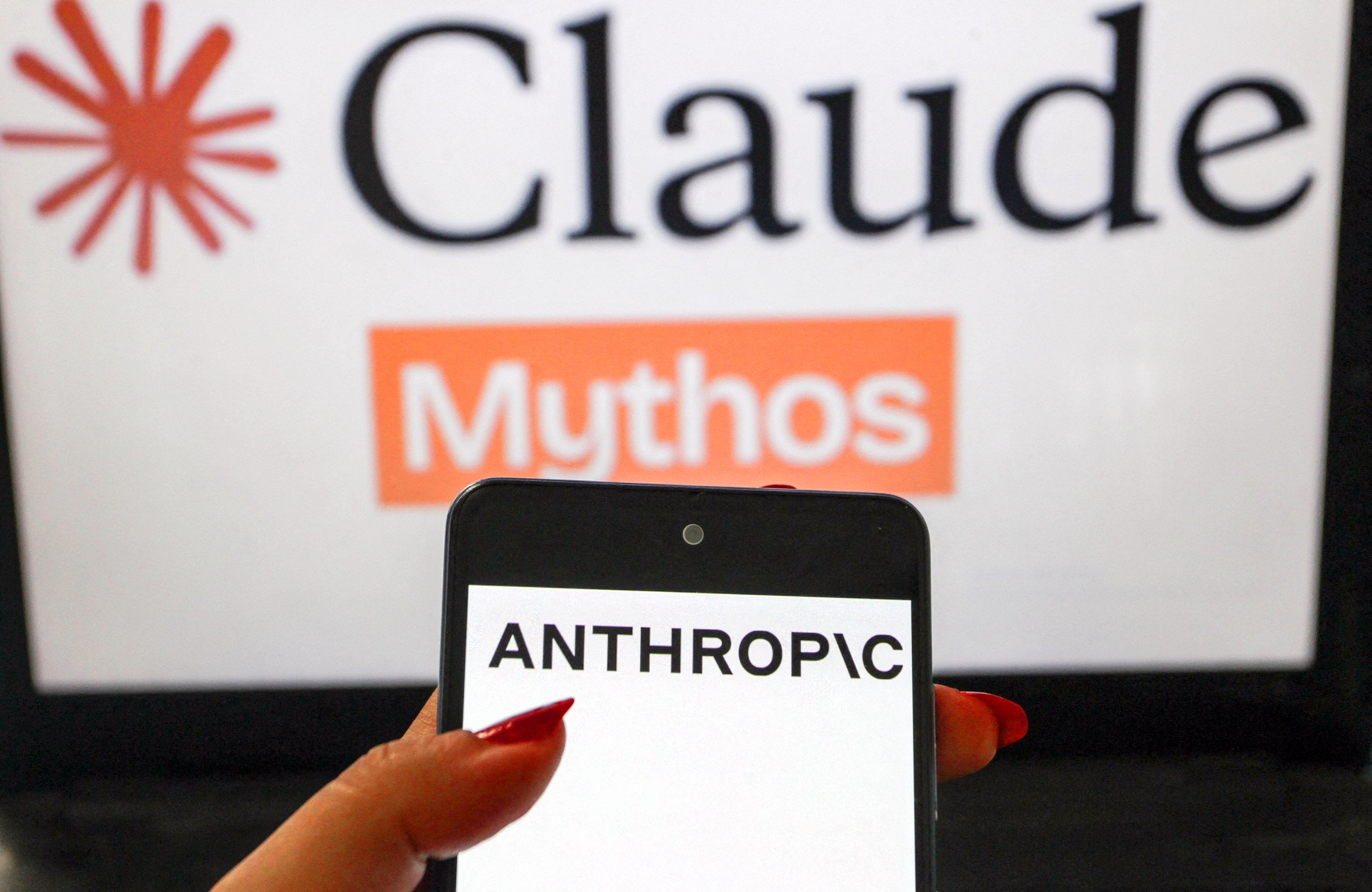 A smartphone showing the Anthropic logo is shown in the foreground with a blurred Claude Mythos themed background in July. Photo: AFP
