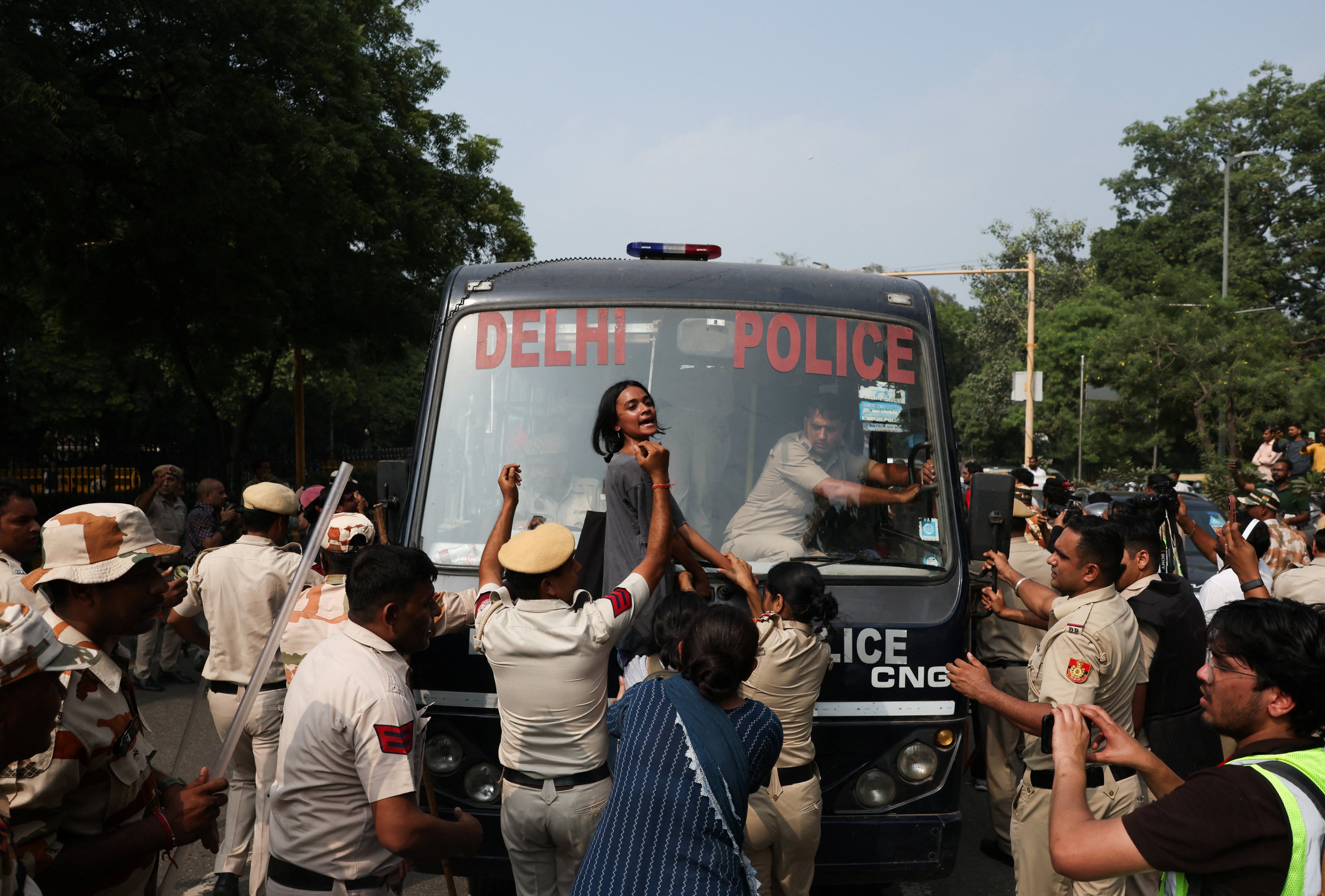 A woman reacts as she tries to stop the police bus carrying detained protesters in New Delhi on Saturday. Photo: Reuters