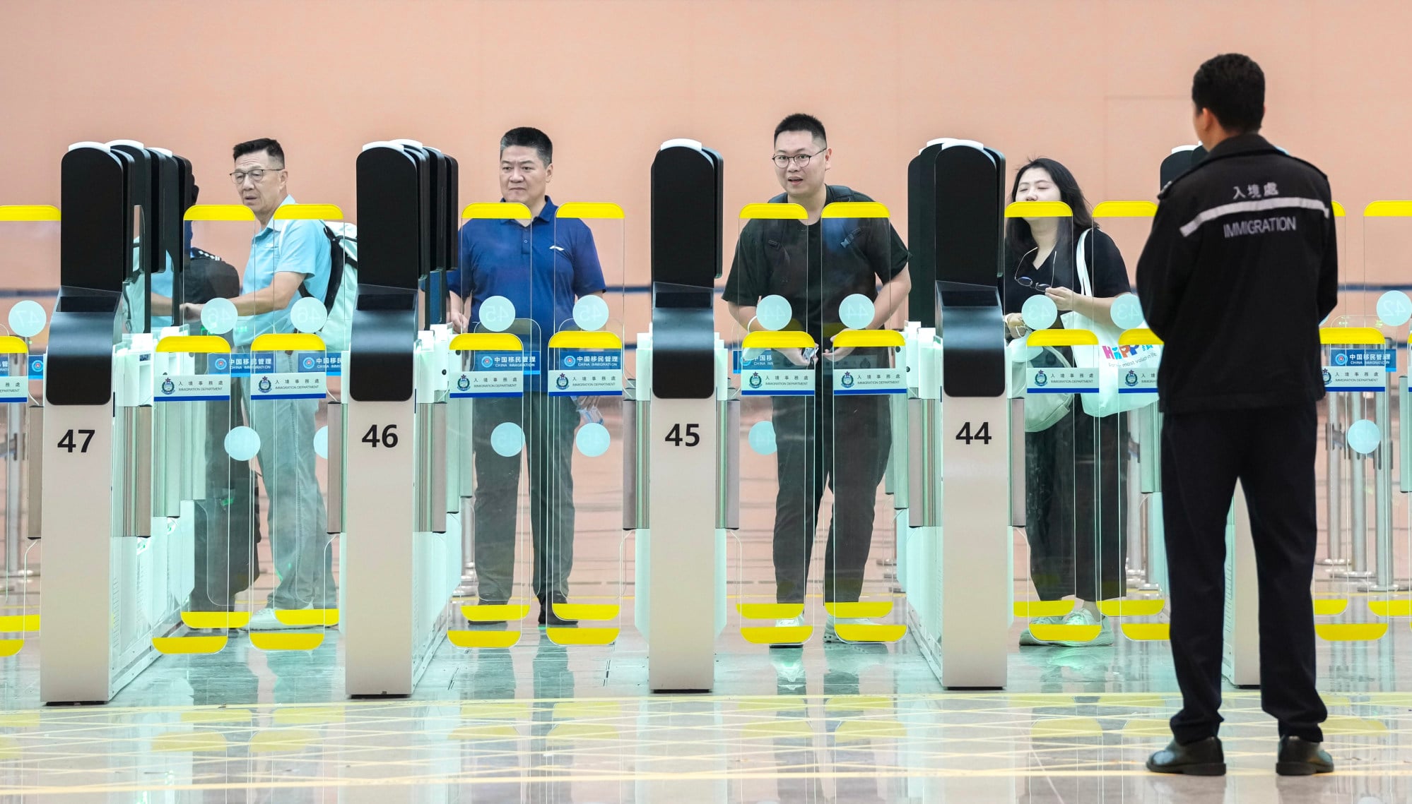 Travellers pass through the automated three-stage gates. Photo: Karma Lo Travellers pass through the automated three-stage gates. Photo: Karma Lo