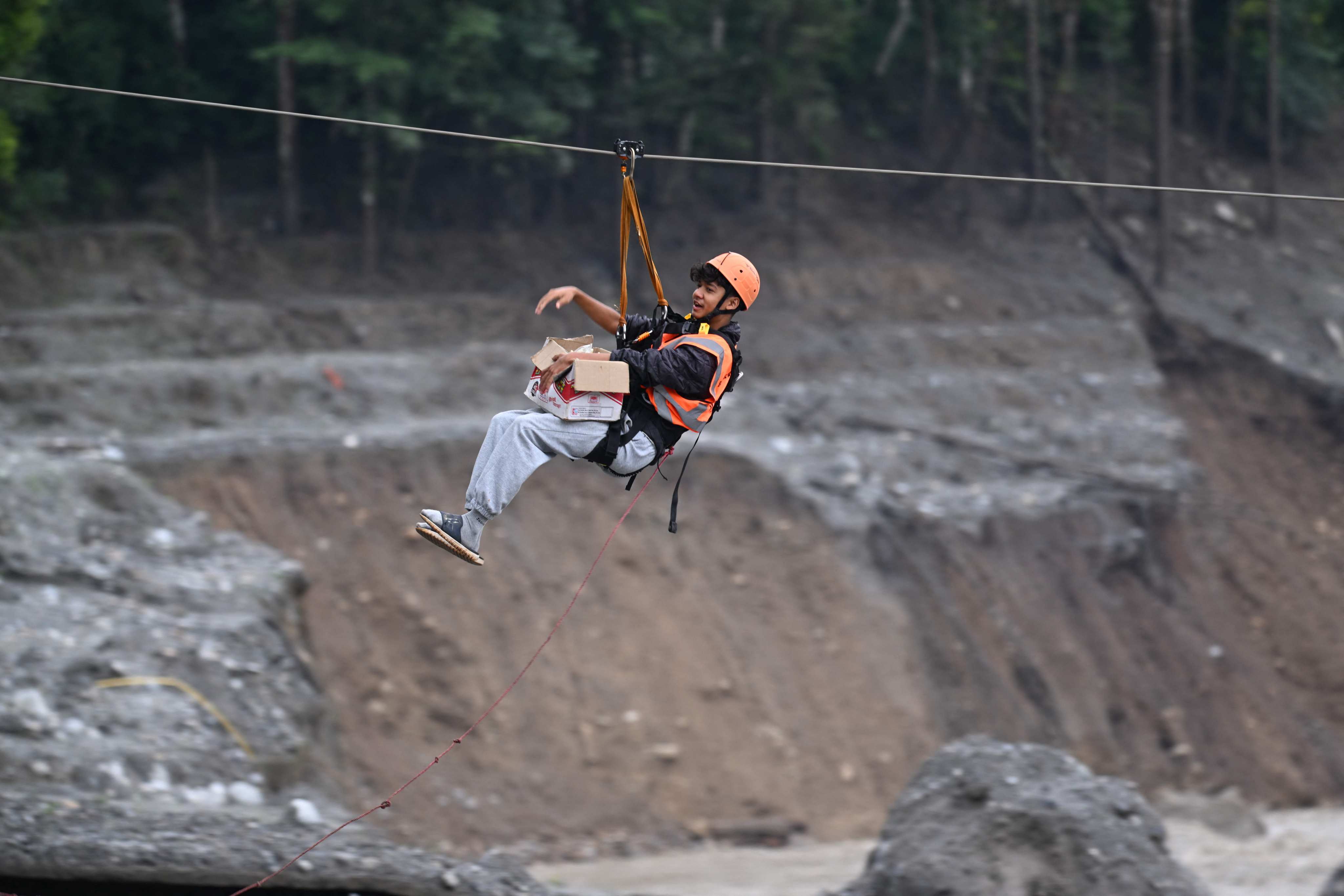 A man crosses the Trishuli River via a zip line in Nepal’s Nuwakot district last month. Photo: AFP