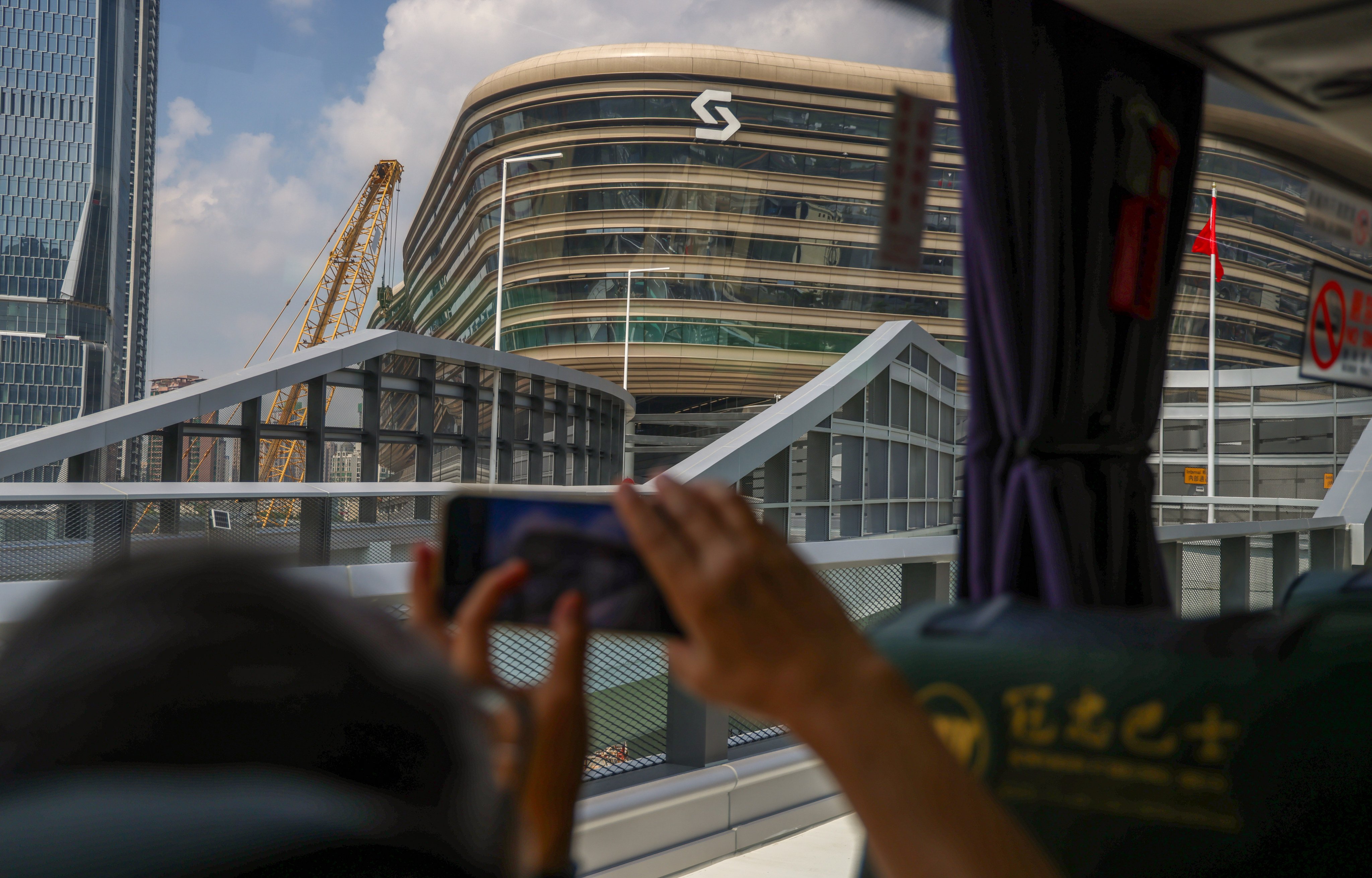 A tourist aboard a cross-border coach takes photos of the newly opened Huanggang Port building on Monday. Photo: Silvia Siu