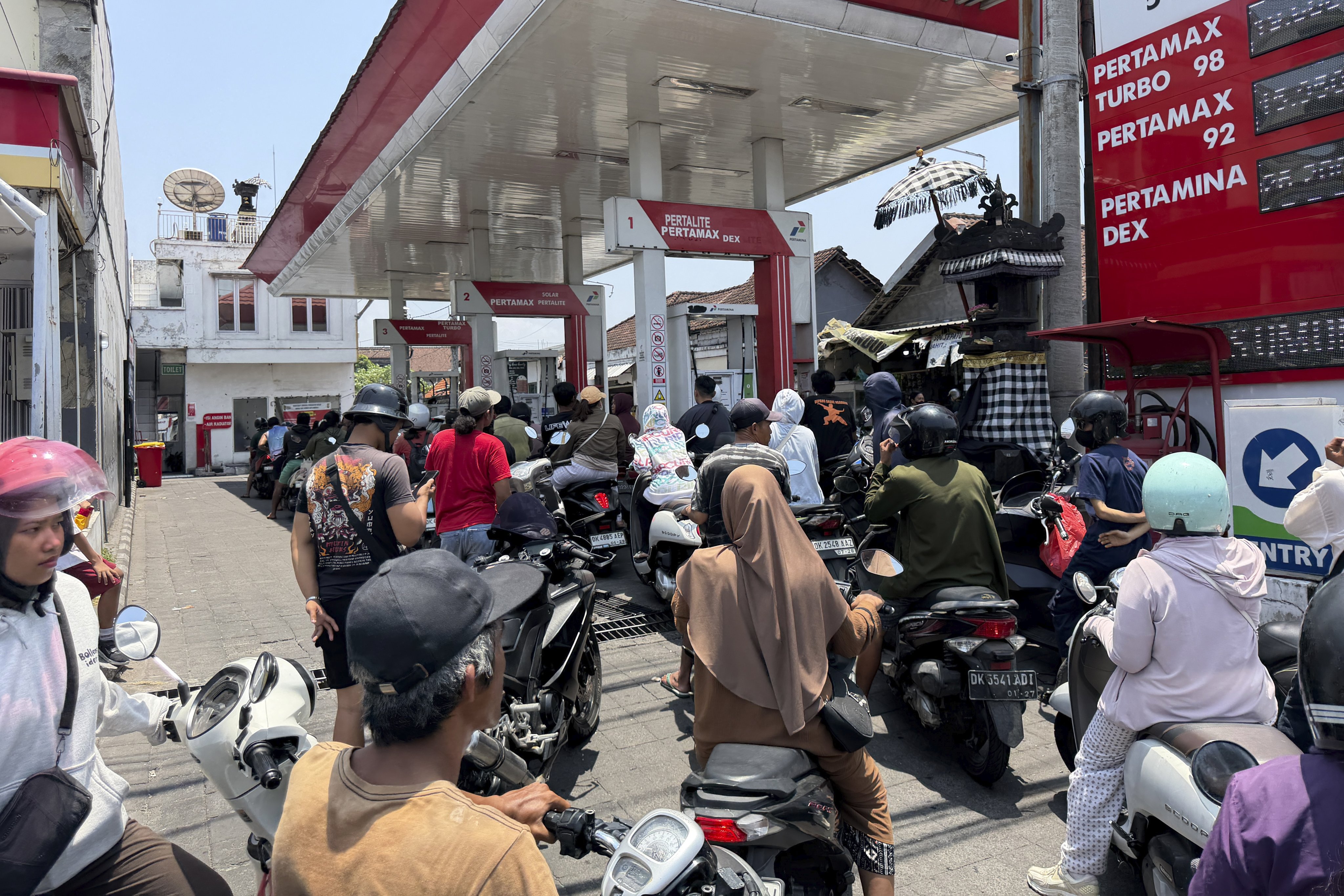 Motorcyclists queue to refuel at a petrol station in Denpasar, Bali, on Tuesday, amid reports of shortages. Photo: EPA