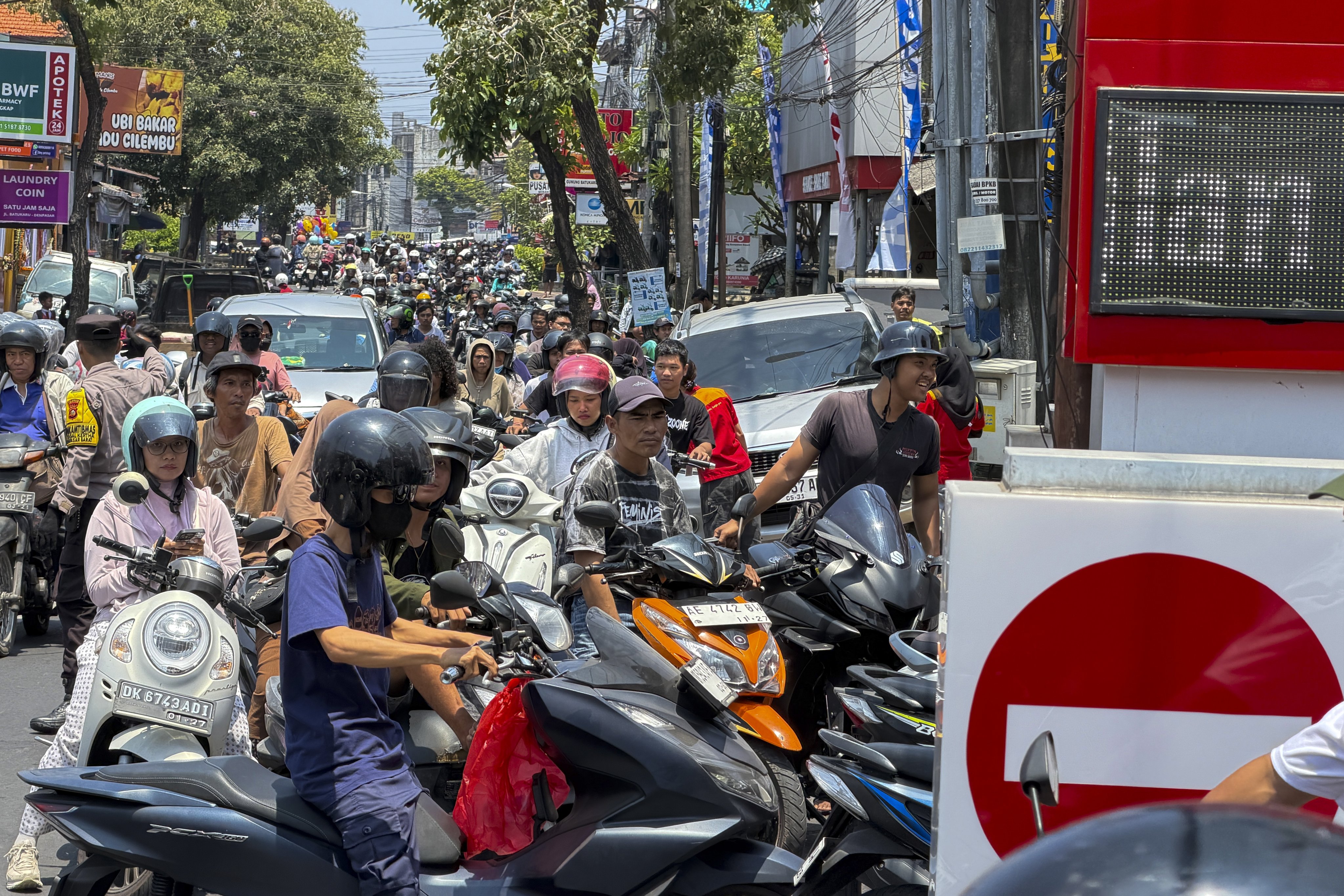 Motorcyclists queue to refuel at a petrol station in Denpasar, Indonesia's Bali island, on Tuesday. Photo: EPA