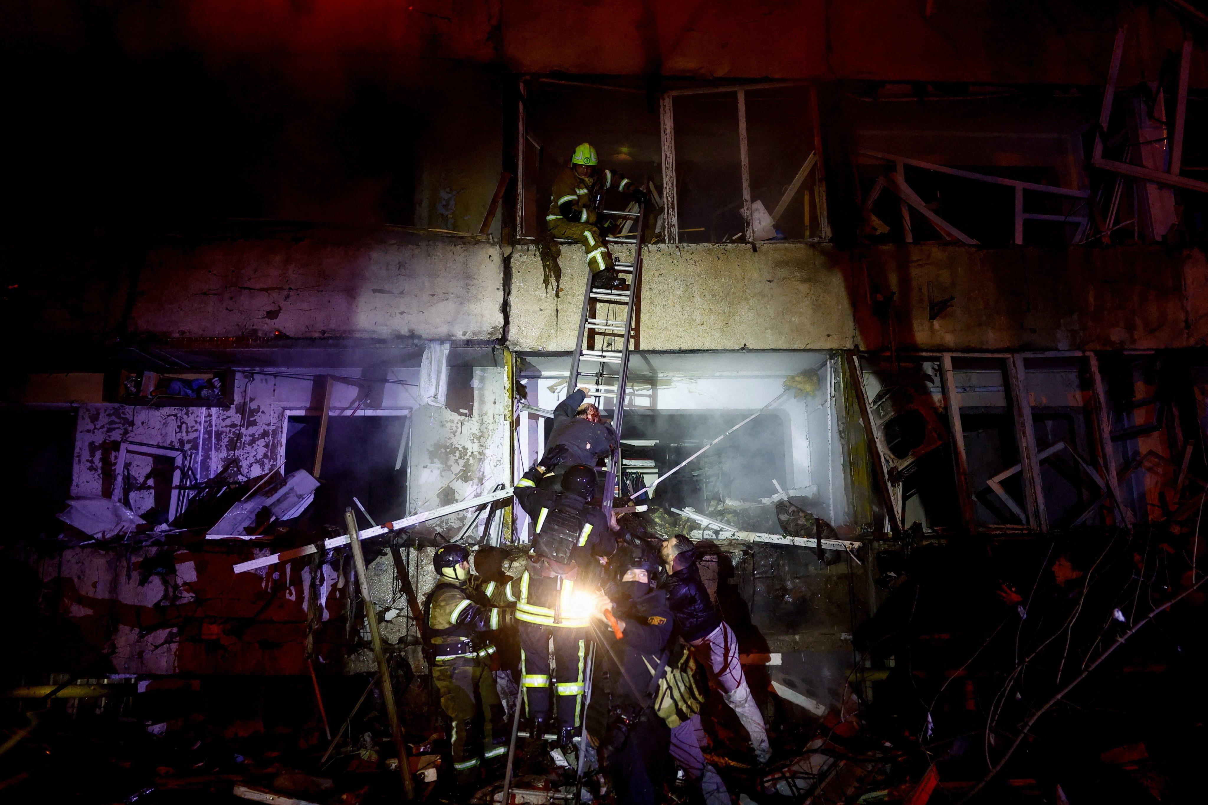 An injured man climbs down a ladder at a Kyiv residential building hit in a Russian missile strike on Tuesday. Photo: Reuters