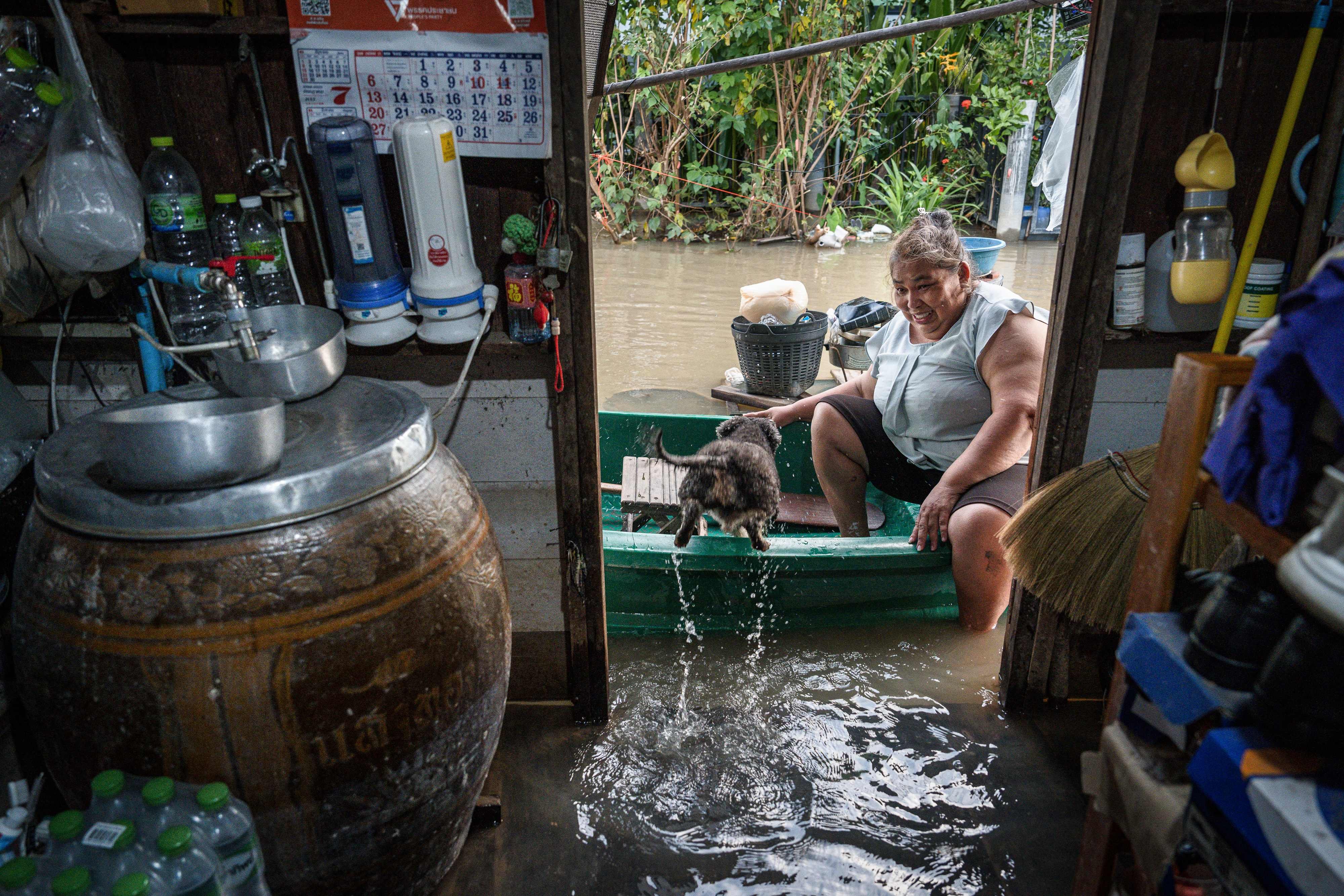 Ayutthaya resident Yupin Nakbanlang, 57, sits in a boat in front of the entrance of her flooded home in Ayutthaya province on October 6. Photo: AFP