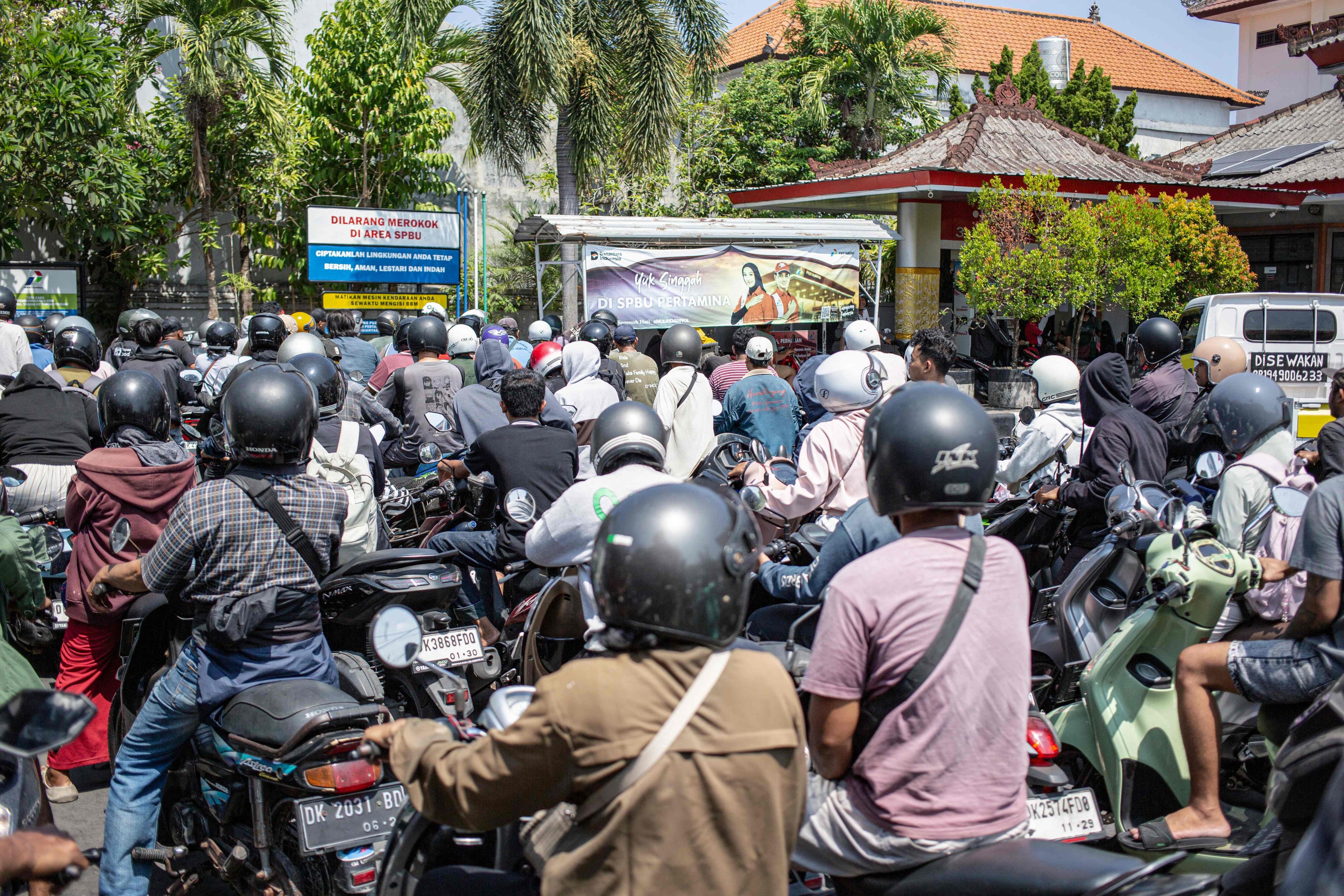 Motorcyclists queue to refuel at a petrol station in Denpasar on Tuesday amid reports of a fuel supply shortage. Photo: AFP