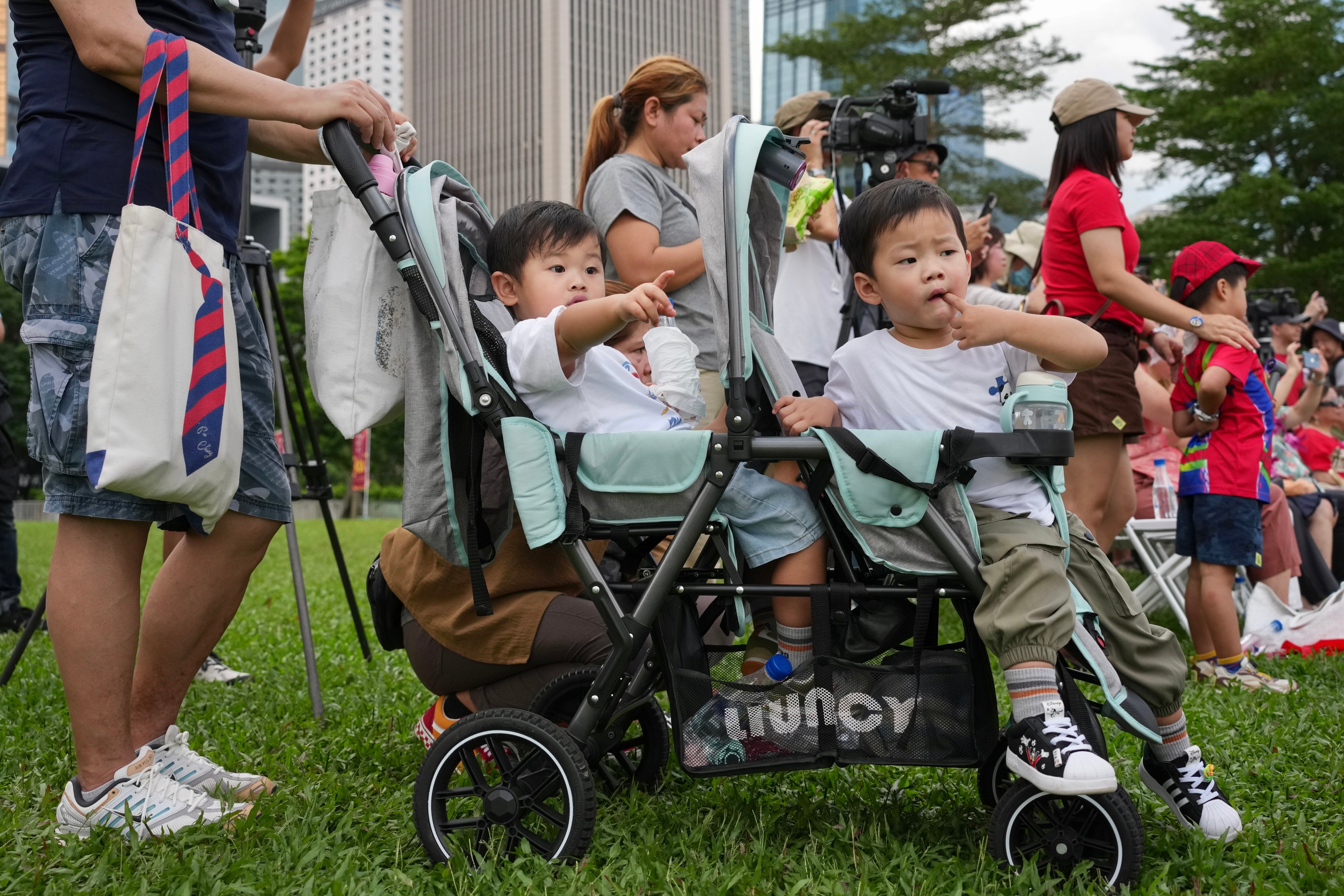 Young children sit in a double stroller at Tamar Park on October 4. Hong Kong authorities have introduced financial incentives such as cash subsidies for newborn baby bonuses to encourage couples to expand their families.  Photo: Karma Lo