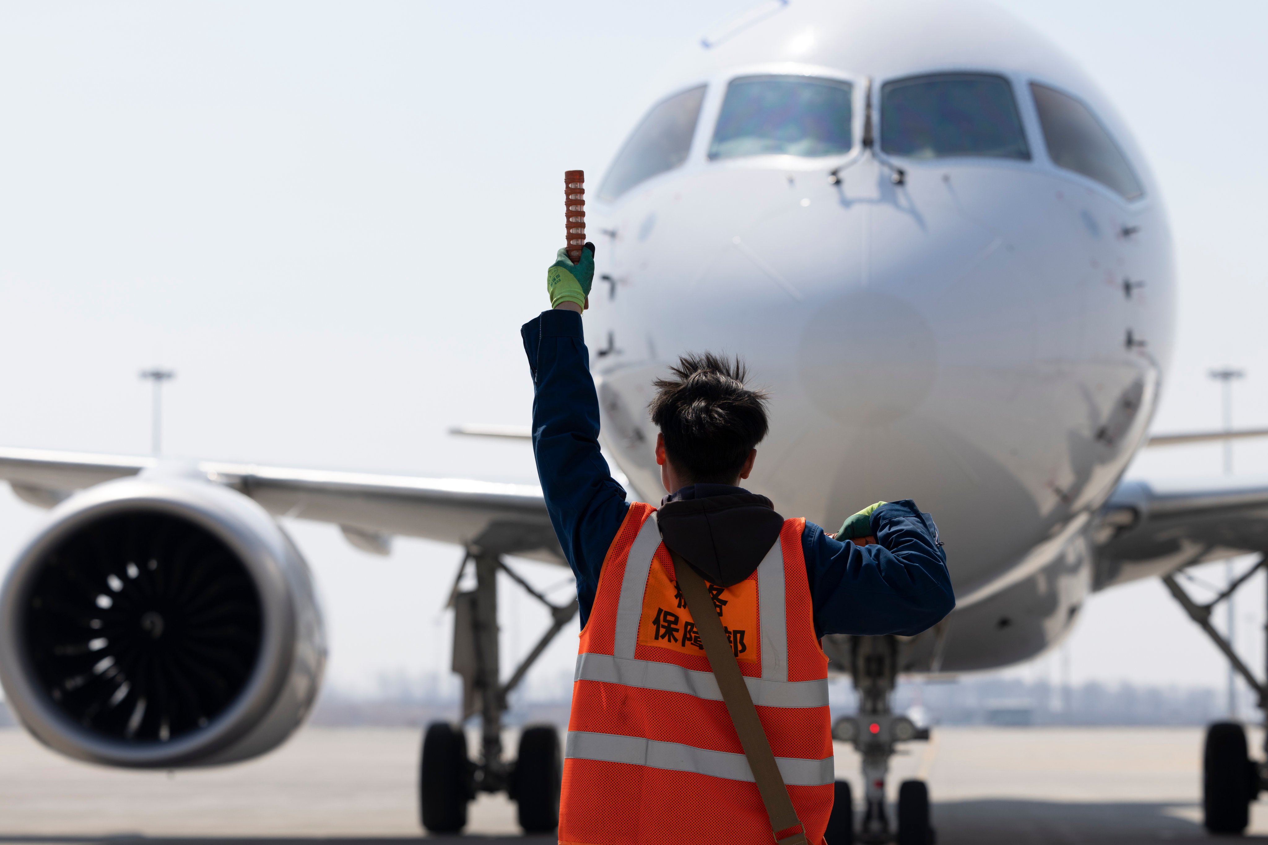 A ground crew member directs a China Eastern Airlines C919 at Harbin Taiping International Airport in April. Photo: Xinhua