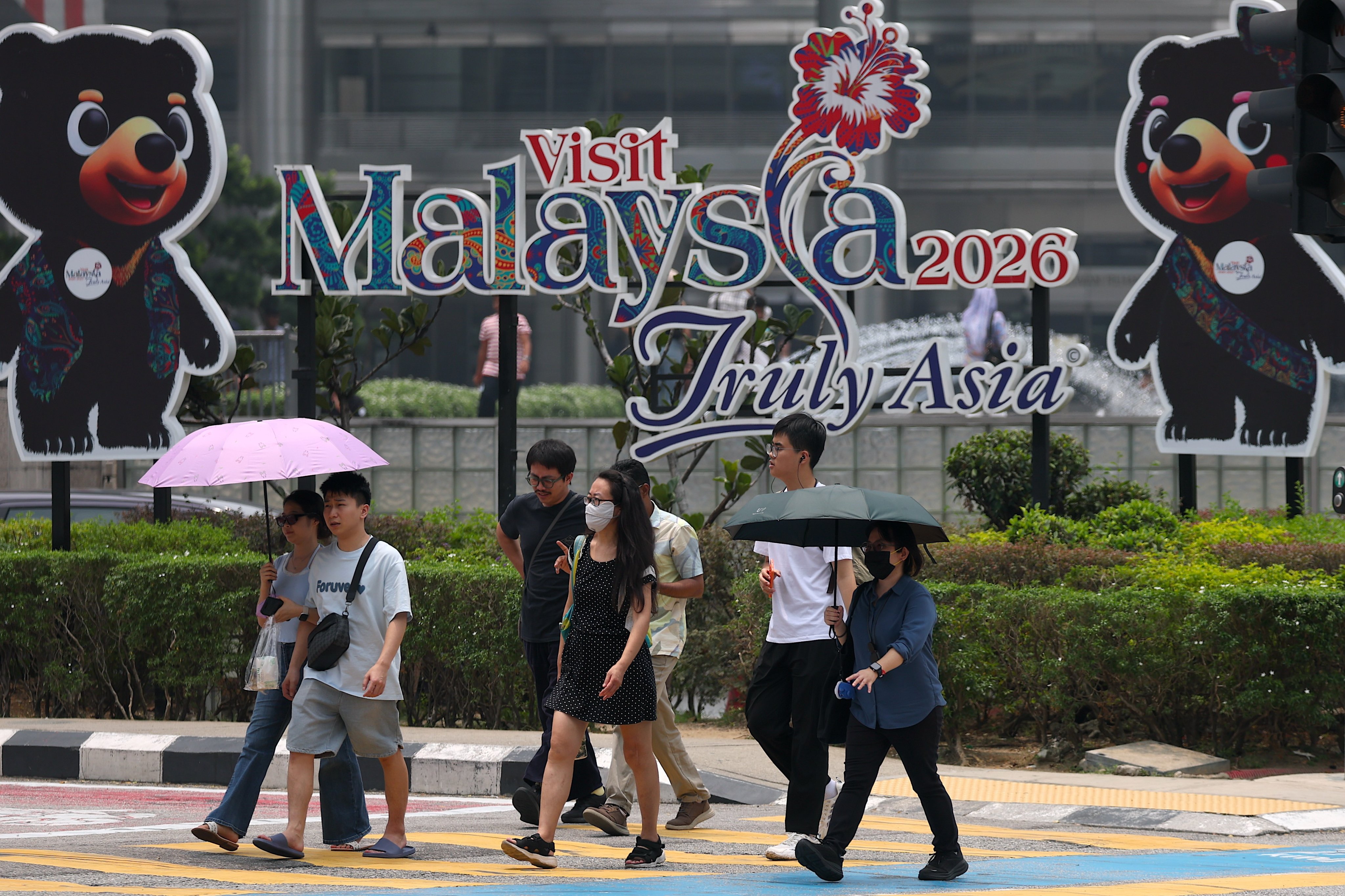 Pedestrians, including young people, walk along a road in Kuala Lumpur, Malaysia, last month. Photo: EPA