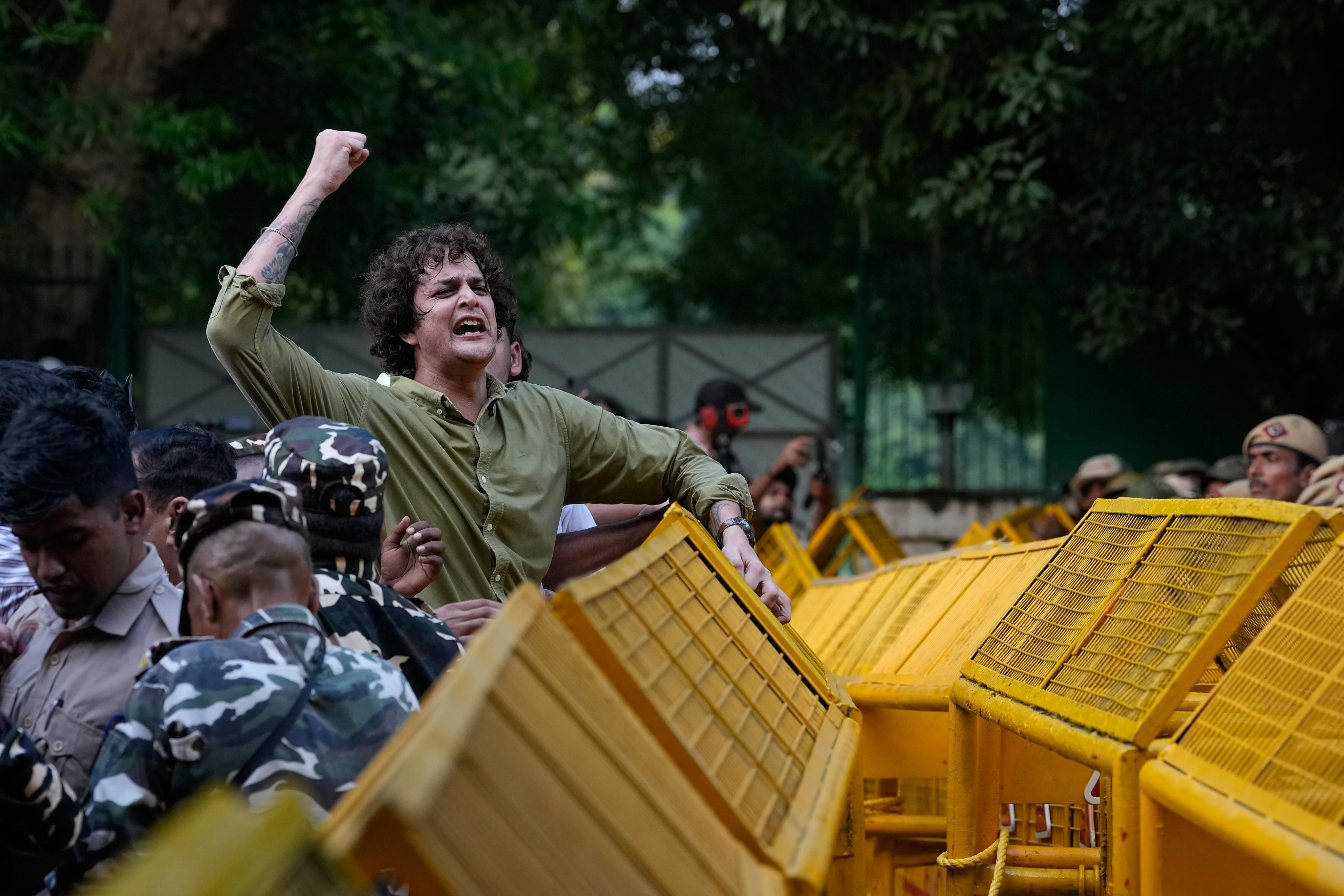 A protester scales a police barricade during a demonstration in New Delhi, India, on Monday. Photo: AP