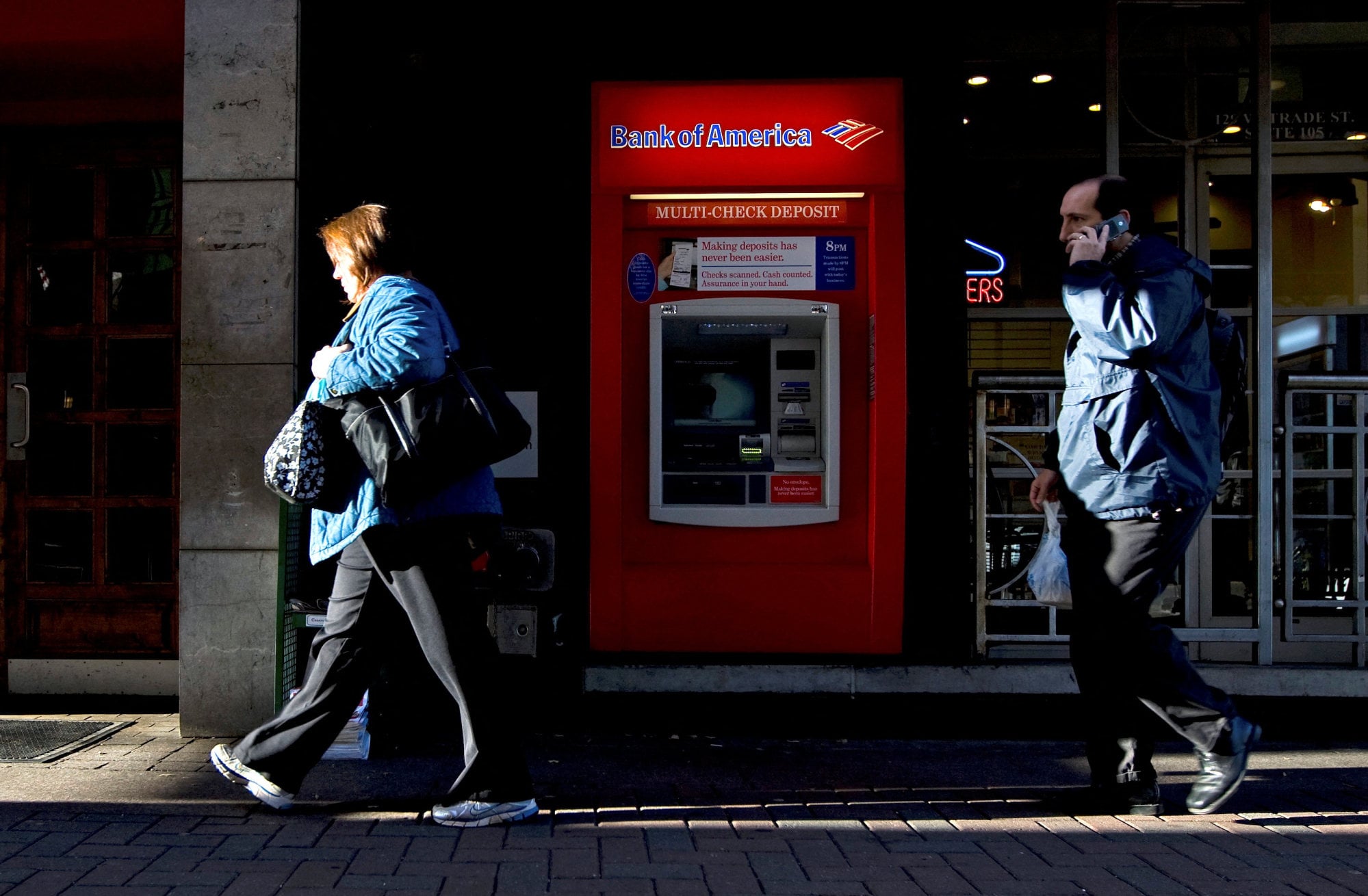Pedestrians walk past a Bank of America ATM in Charlotte, North Carolina. Photo: Reuters