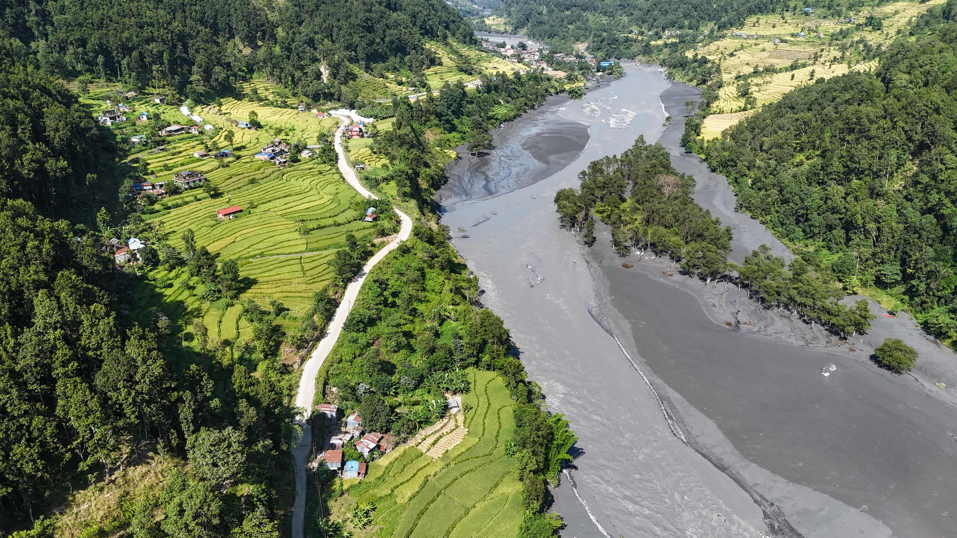 Muddy water flows through the Budhi Gandaki river, separating Nepal’s Gorkha (left) and Dhading districts on Wednesday, in the aftermath of a flash flood caused by a dry landslide. Photo: AFP