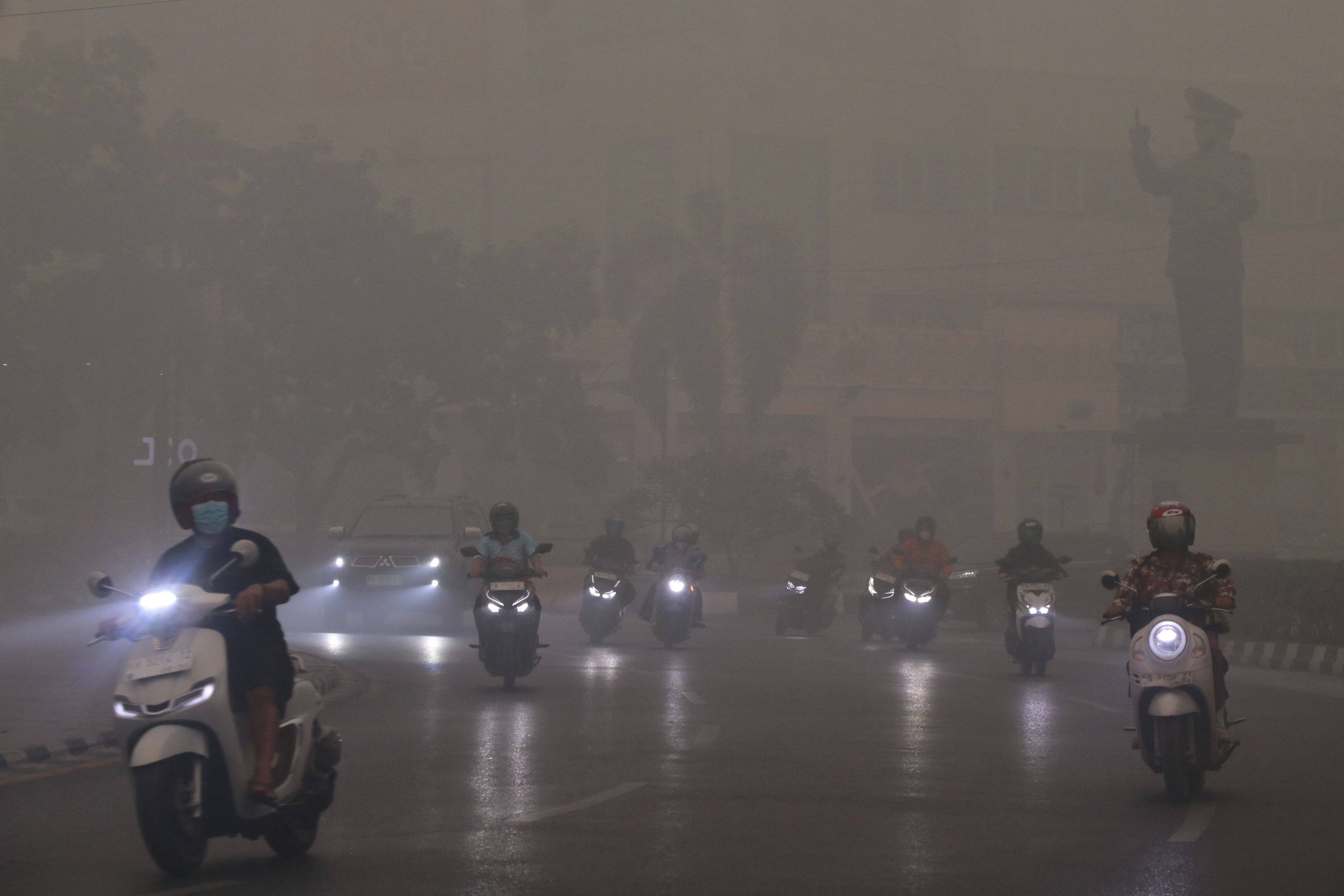 Motorcyclists ride in Palangkaraya, Indonesia’s Central Kalimantan, on Wednesday amid thick haze from forest and land fires in the region. Photo: AFP