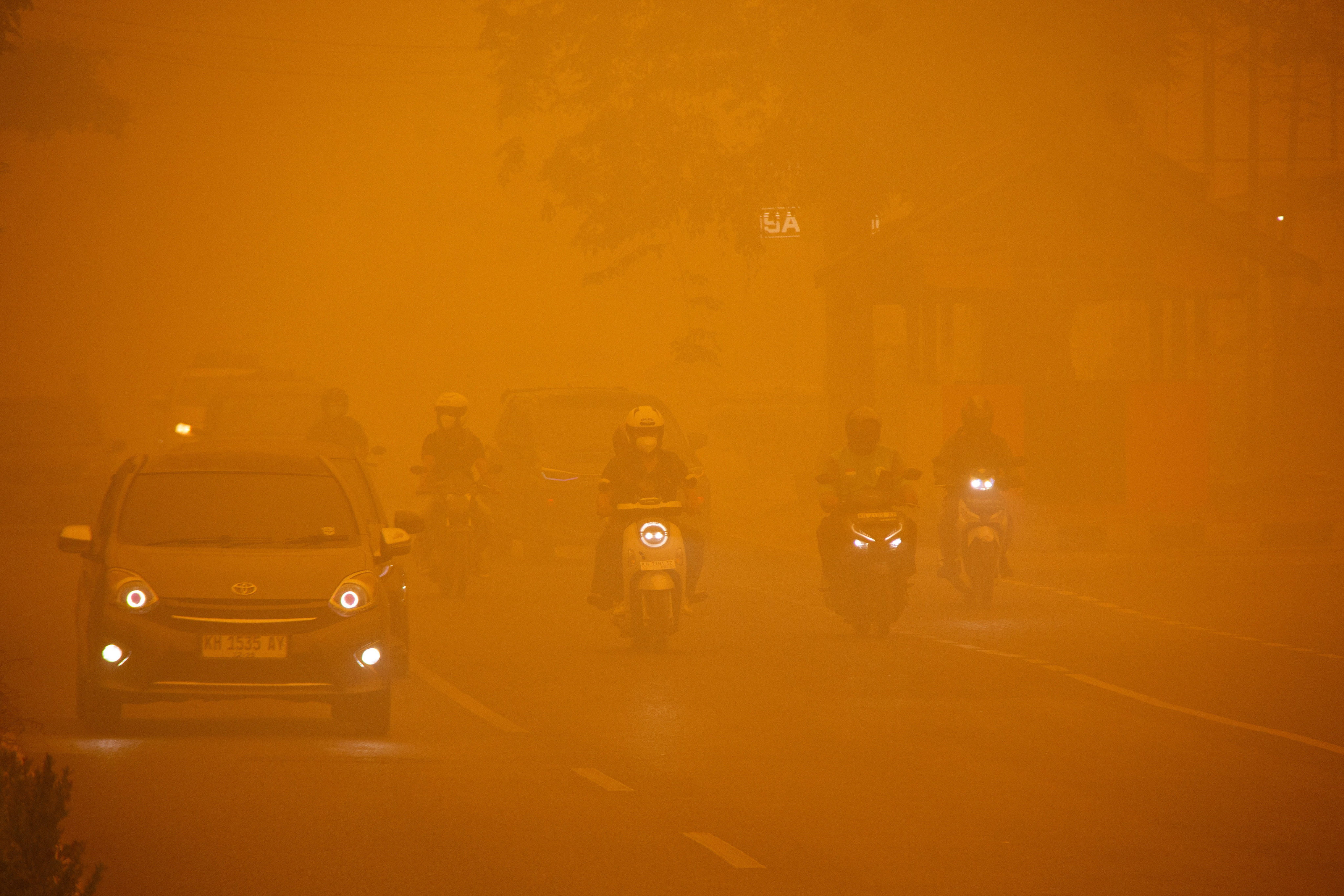 Motorists drive through a main road as haze from wildfires shrouds the area in Palangka Raya, Central Kalimantan, on Wednesday. Photo: Reuters