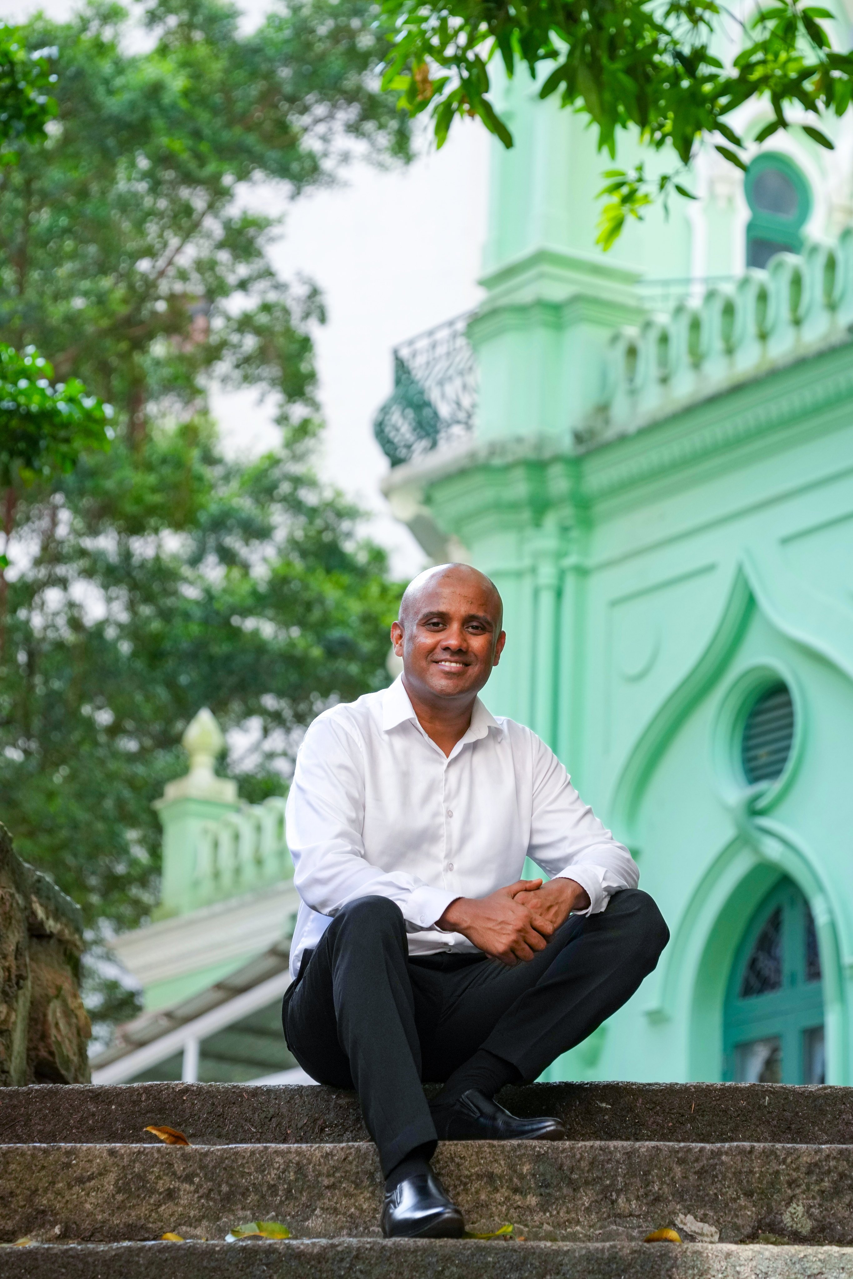 Nifraz Rifaz, a Sri Lankan novelist based in Hong Kong, sits by the Jamia Mosque in Mid-Levels. His debut novel, Paper Planes, is set against the 2019 Easter Sunday attacks in Sri Lanka. Photo: Karma Lo