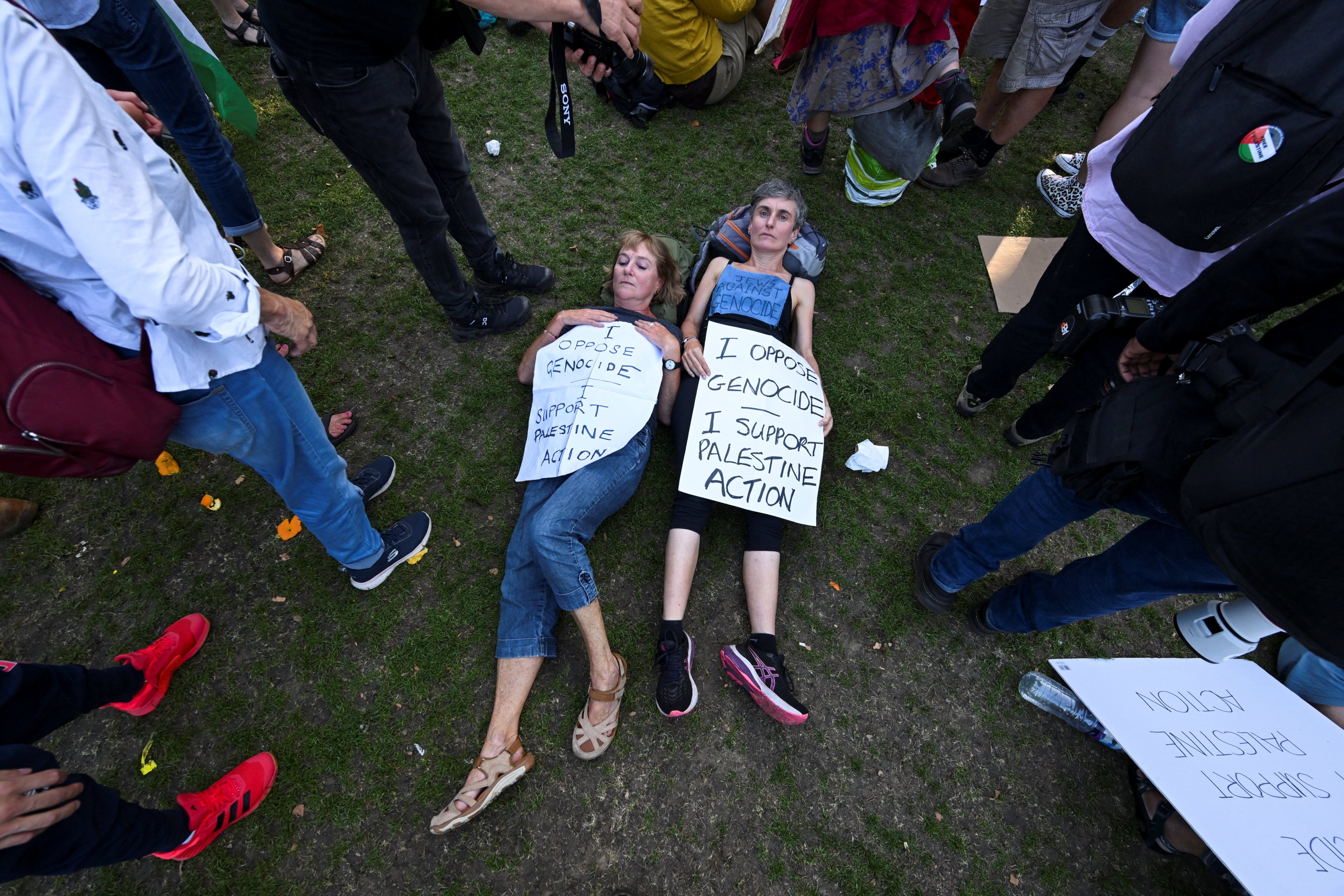 Protesters holding signs lie on the ground during a rally challenging the British government’s proscription of Palestine Action under anti-terrorism laws, in London, August 9, 2025. Photo: Reuters