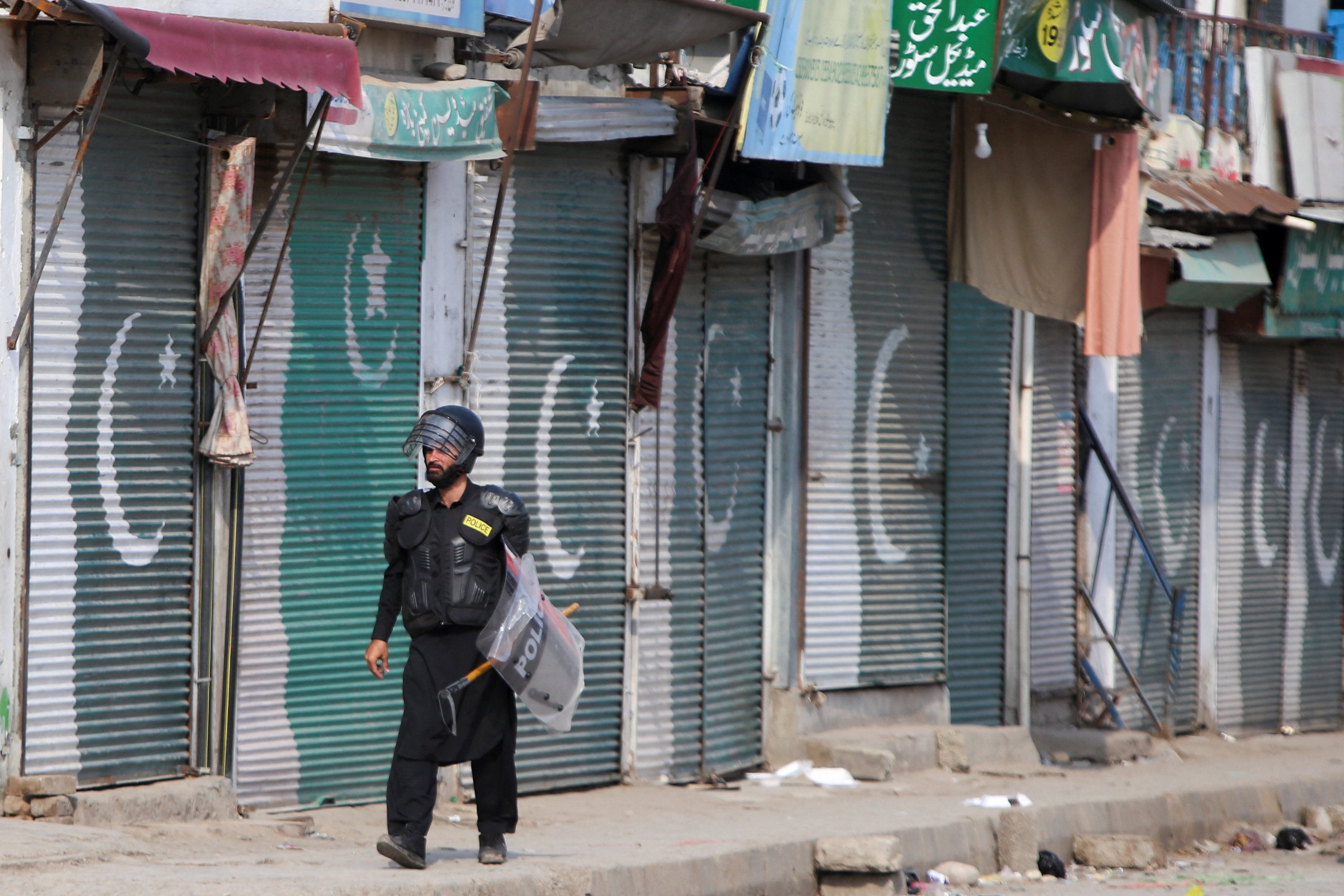 A police officer in riot gear walks past closed shops a day after protests following Pakistan’s imposition of a state of emergency in Khyber Pakhtunkhwa province, Bara, Khyber district, on Wednesday. Photo: Reuters