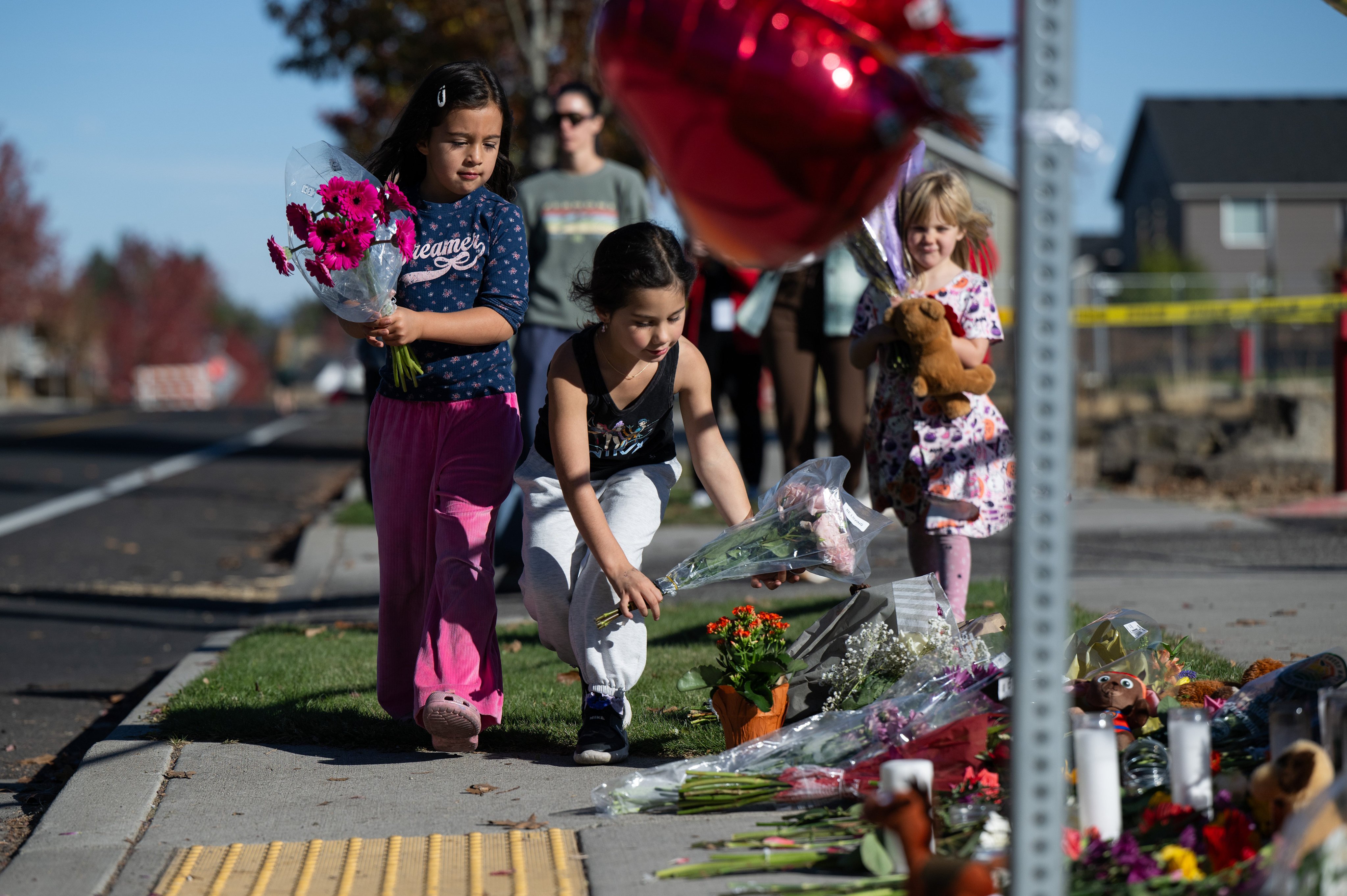 Children place flowers at a makeshift memorial outside Silver Rail Elementary in Bend, Oregon, on Friday. Photo: AP