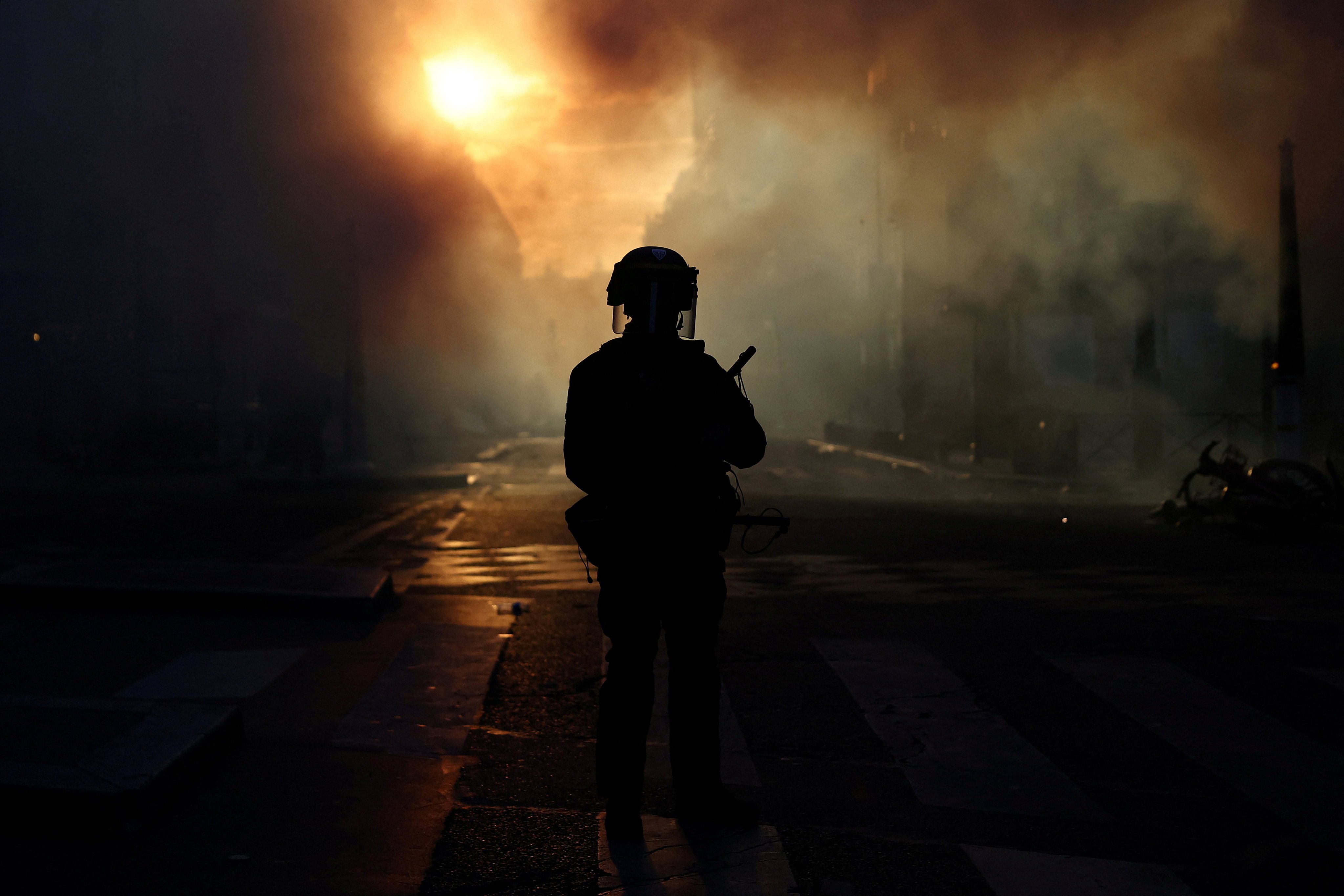 A French riot police officer stands in a street amid clashes with protesters in Paris on Saturday. Photo: Reuters