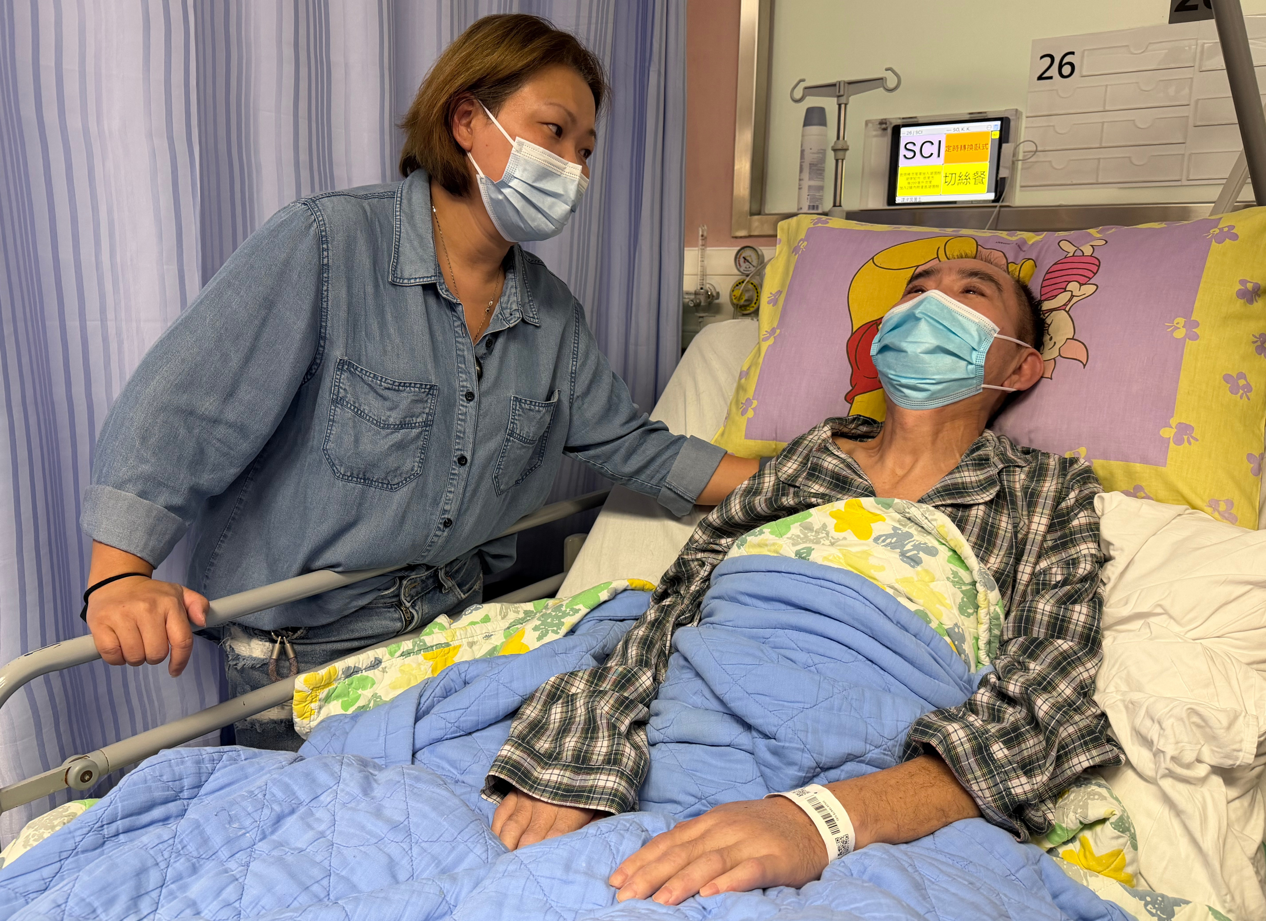 An accident during a delivery left Joe paralysed. The 54-year-old is pictured here in hospital with his wife, Yee. Photo: Fiona Chow