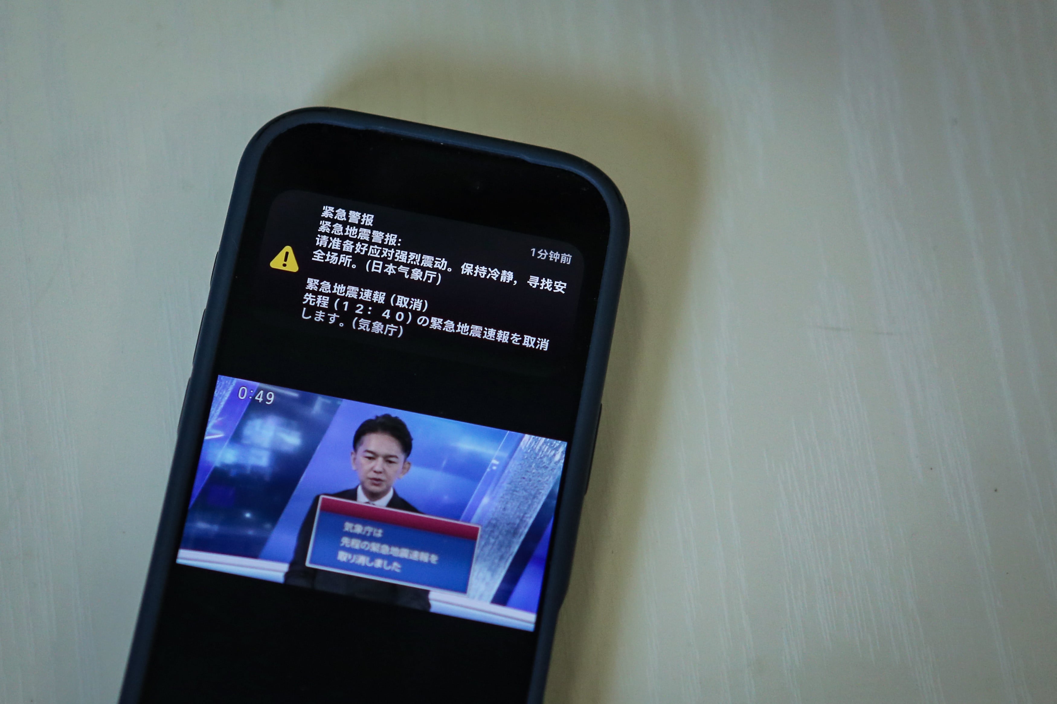 A mobile phone in Tokyo shows a cancellation alert after the Japan Meteorological Agency mistakenly issued a magnitude 9.9 earthquake warning due to a system error on Friday. Photo: Xinhua