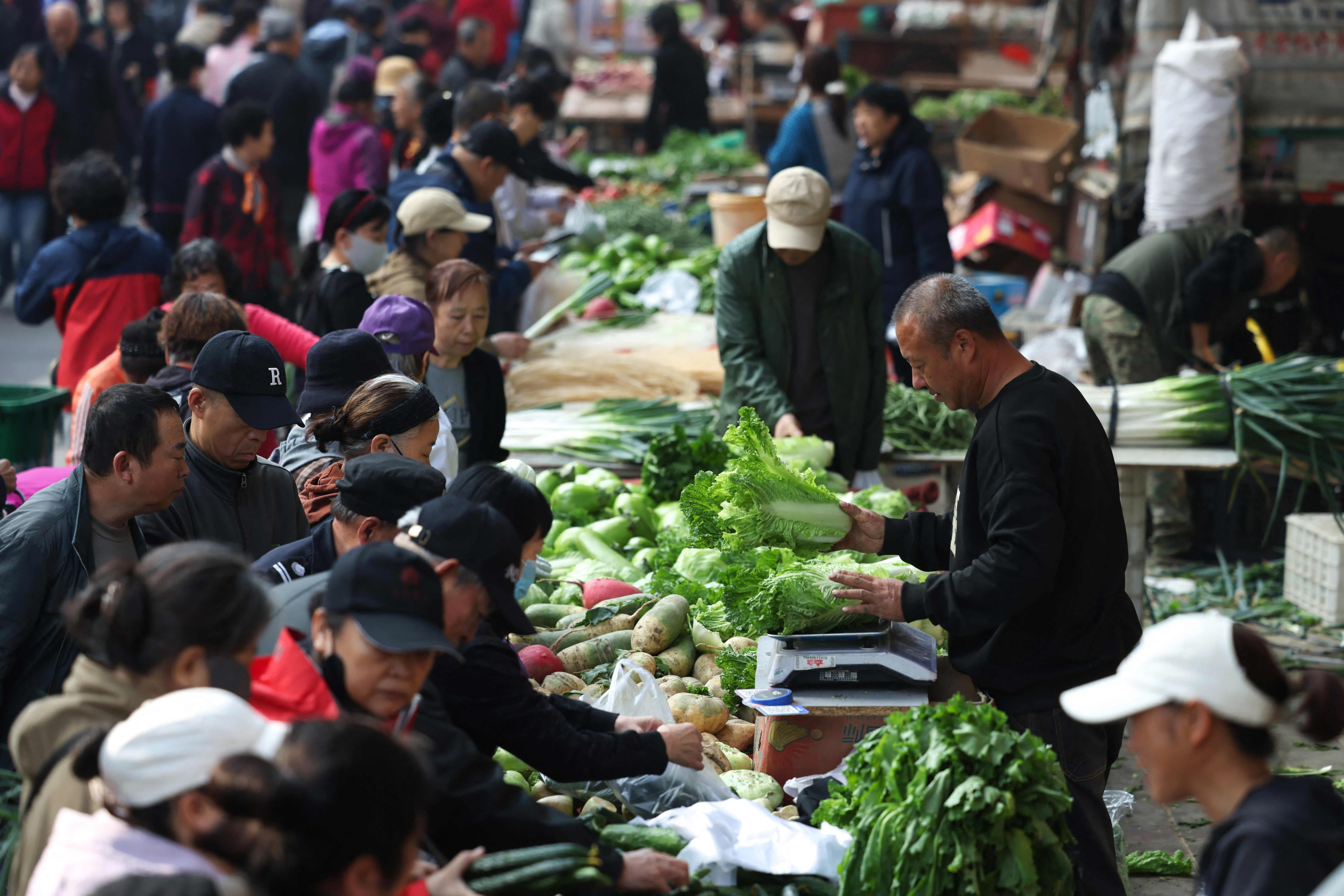 People buy vegetables at a market in Shenyang, Liaoning province, on Wednesday. Photo: AFP