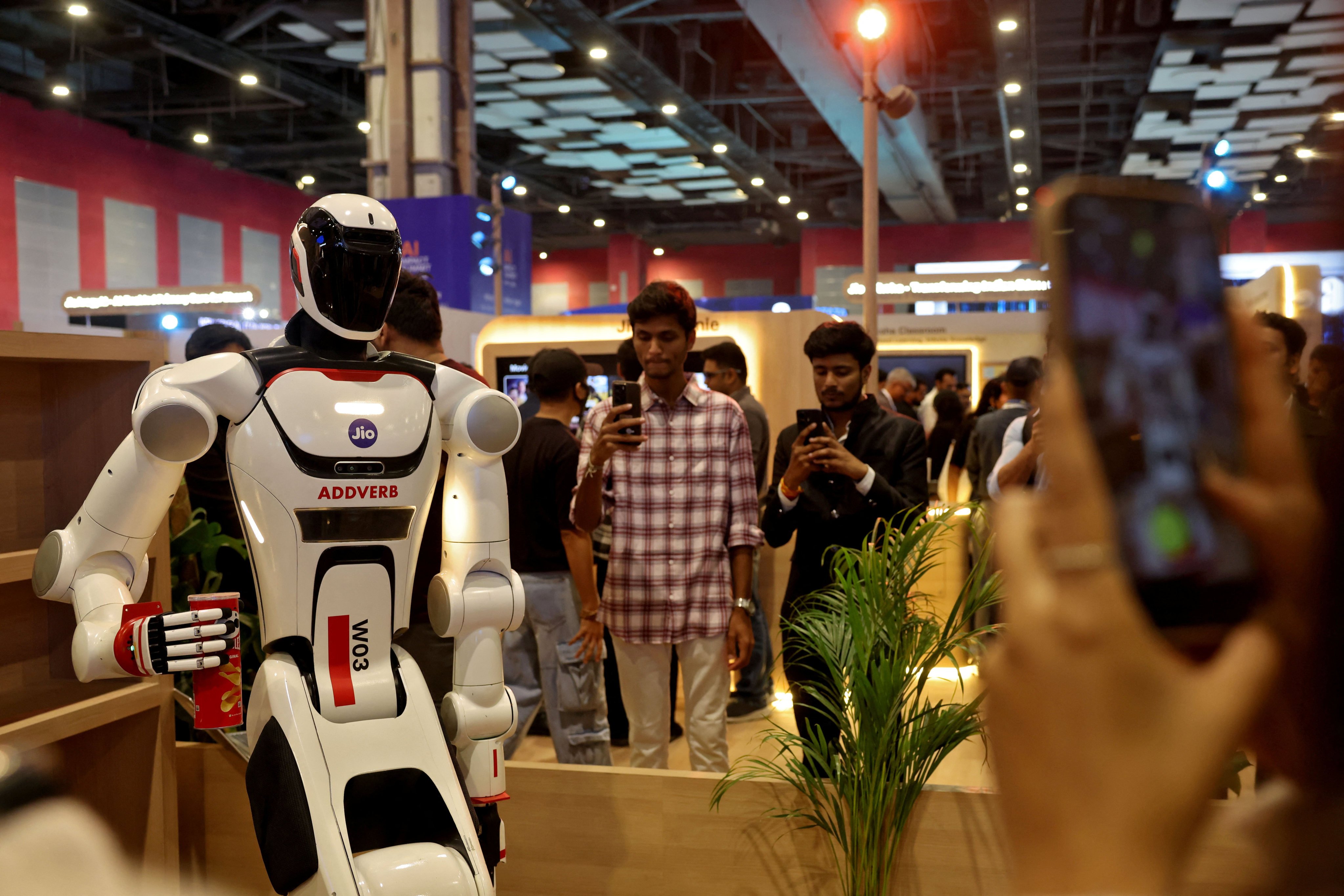 Visitors use their mobile phones to take pictures of a humanoid robot at one of the venues for the AI Impact Summit, in New Delhi in February. Photo: Reuters