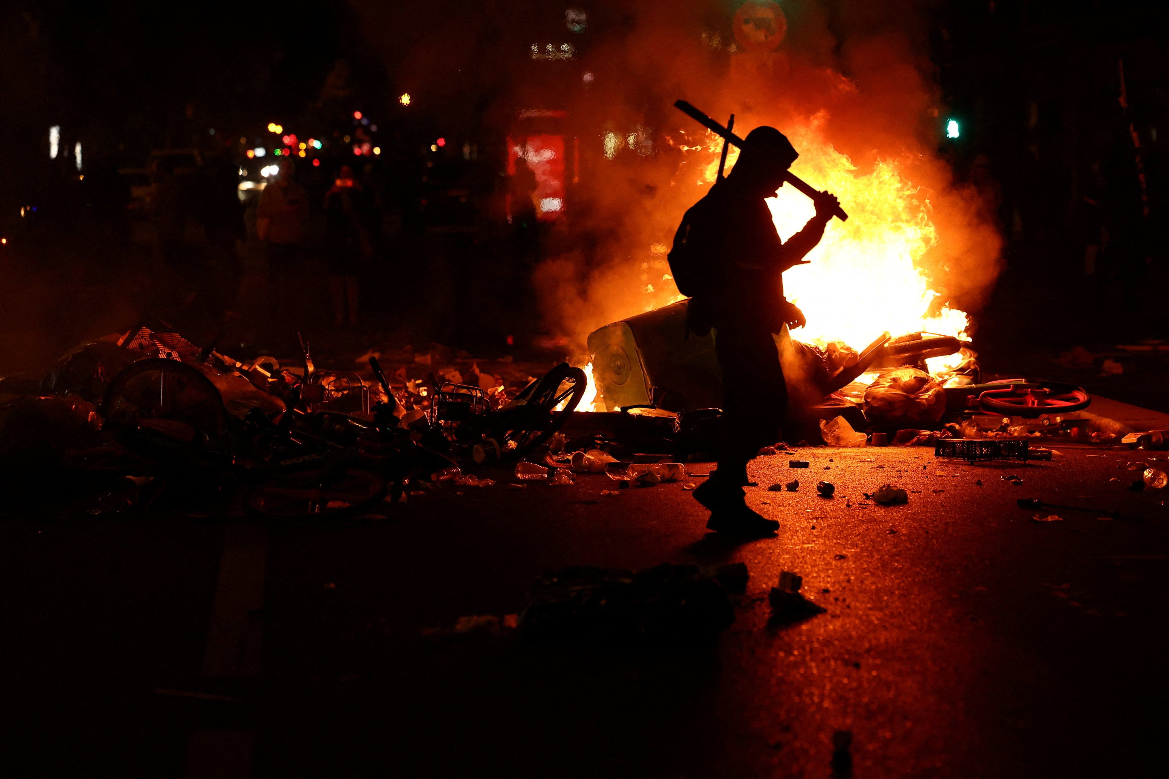 A person walks as flames rise during civil unrest in Paris, on Sunday. Photo: Reuters