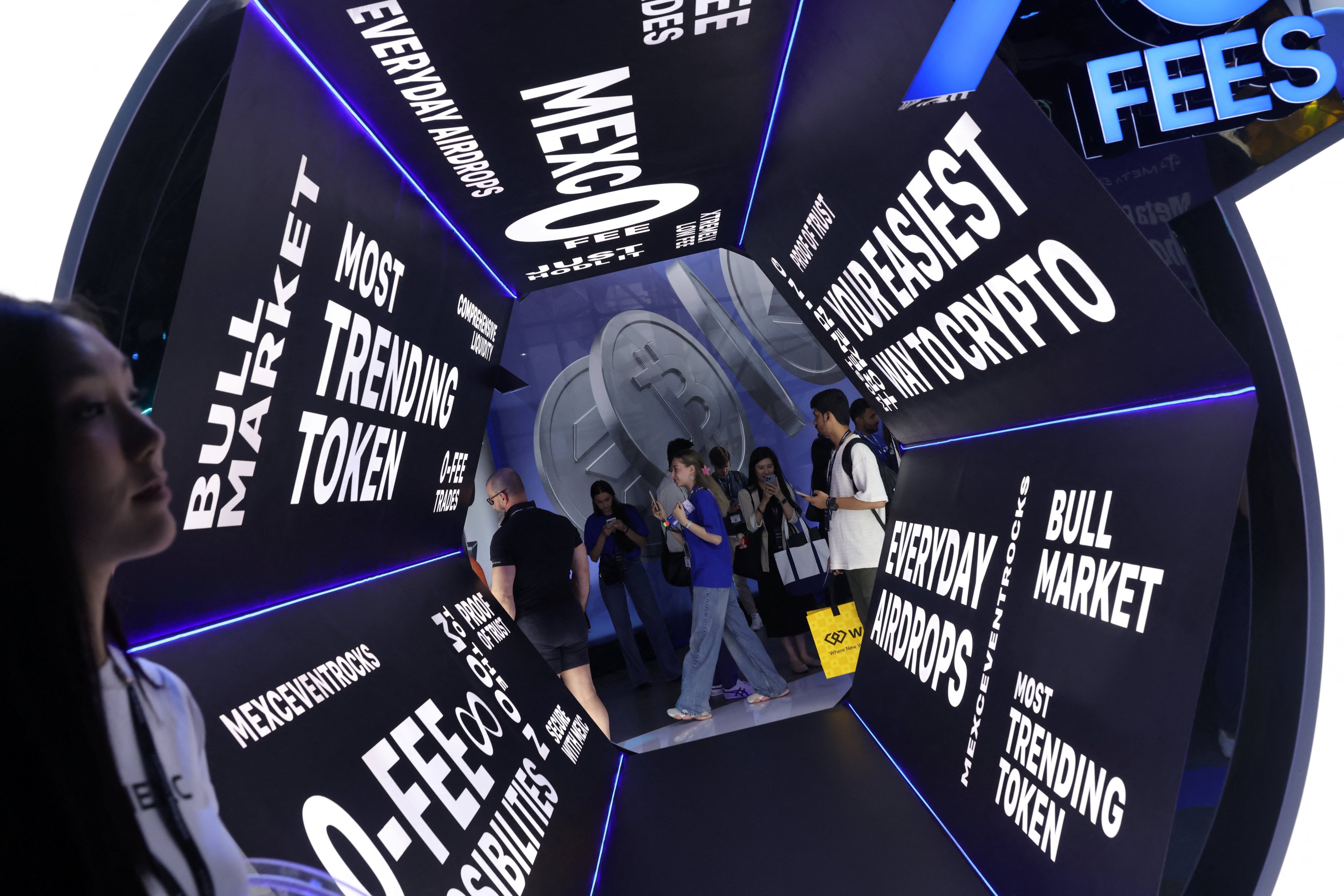 Attendees pass cryptocurrency signage at the Token2049 crypto conference in Singapore on October 1, 2025. Photo: Reuters
