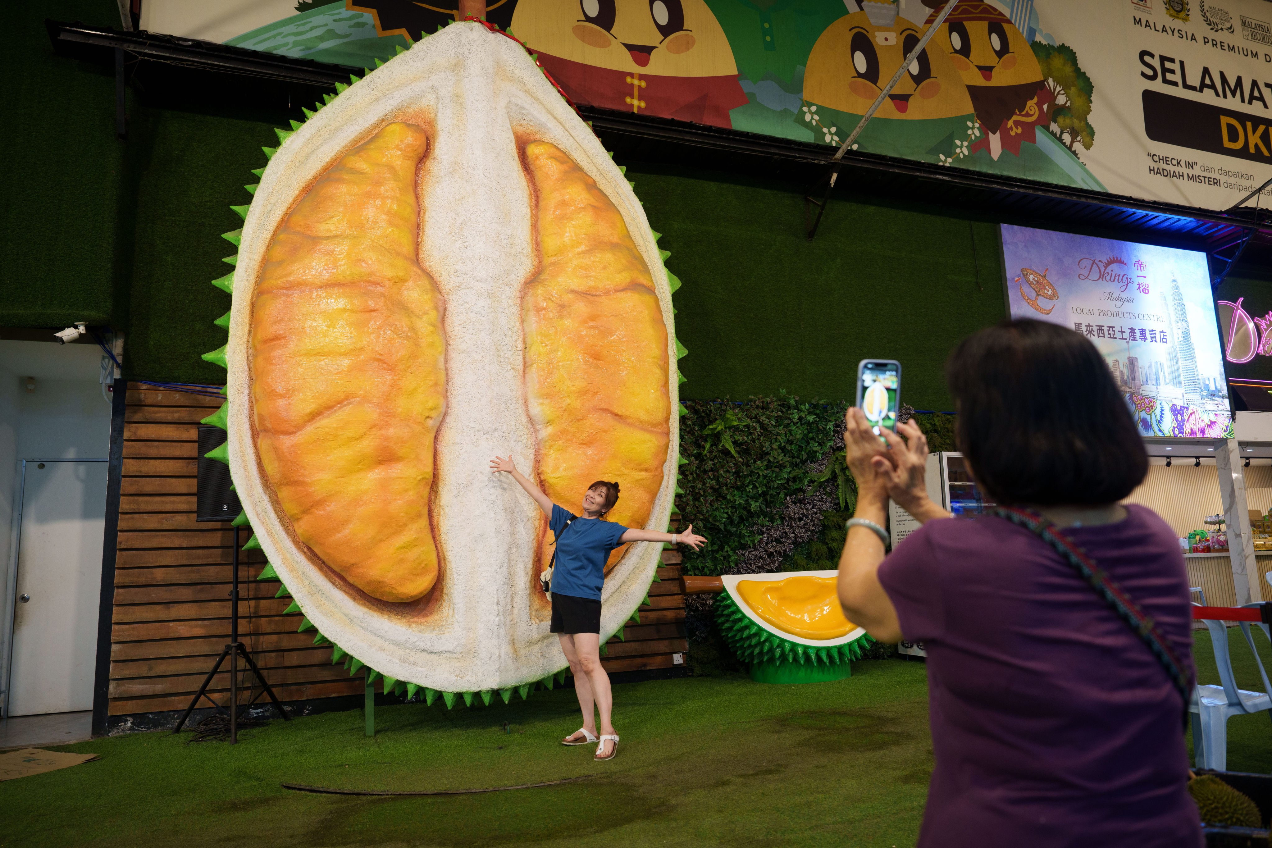 A customer poses beside a giant durian display at a stall in Petaling Jaya, Malaysia, on June 22. Photo: AP