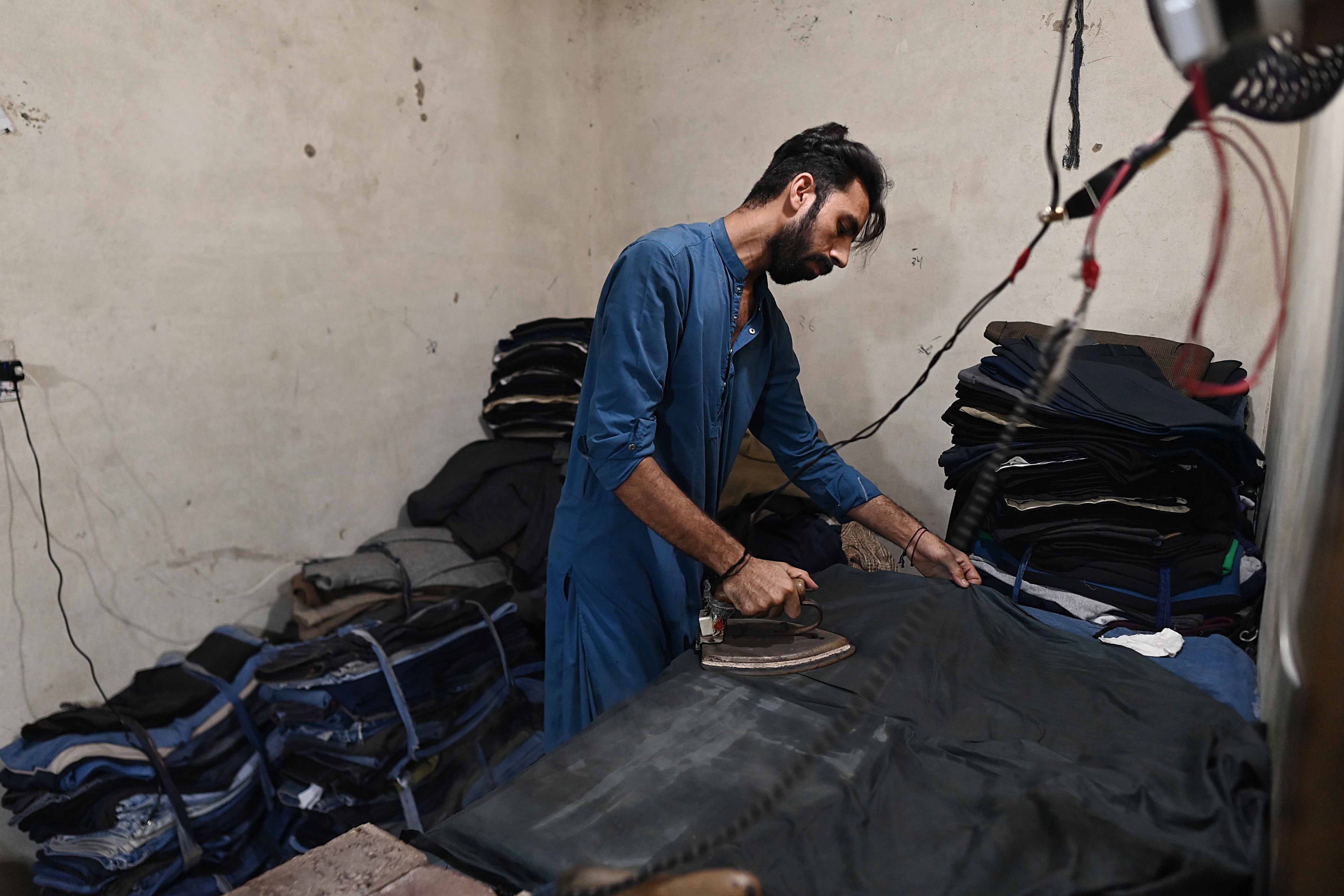 A worker irons garments at factory in Karachi, Pakistan, on Monday. Photo: EPA