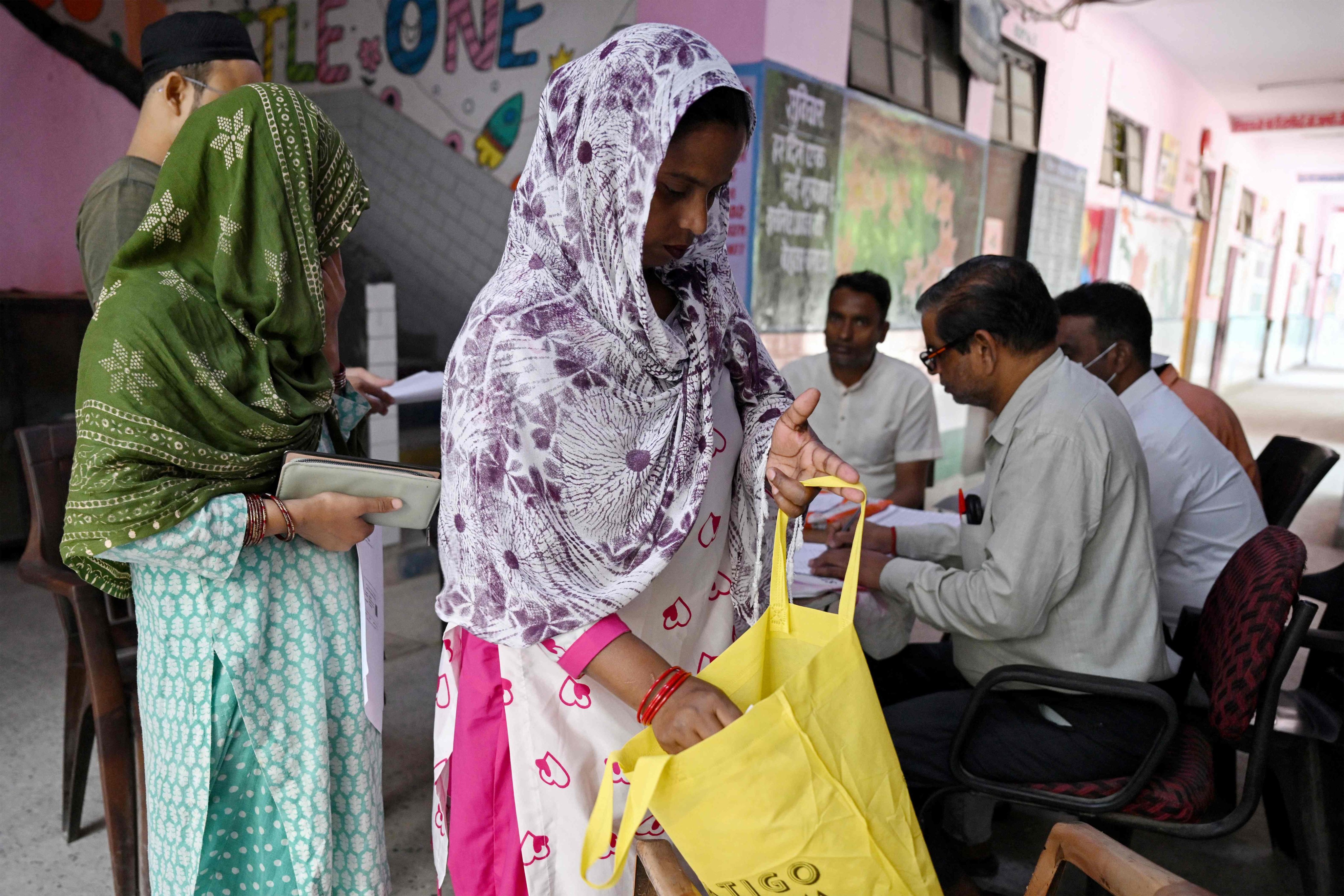 Laddli Khatun searches her bag for documents to register for the draft electoral roll in New Delhi on Sunday. Photo: AFP