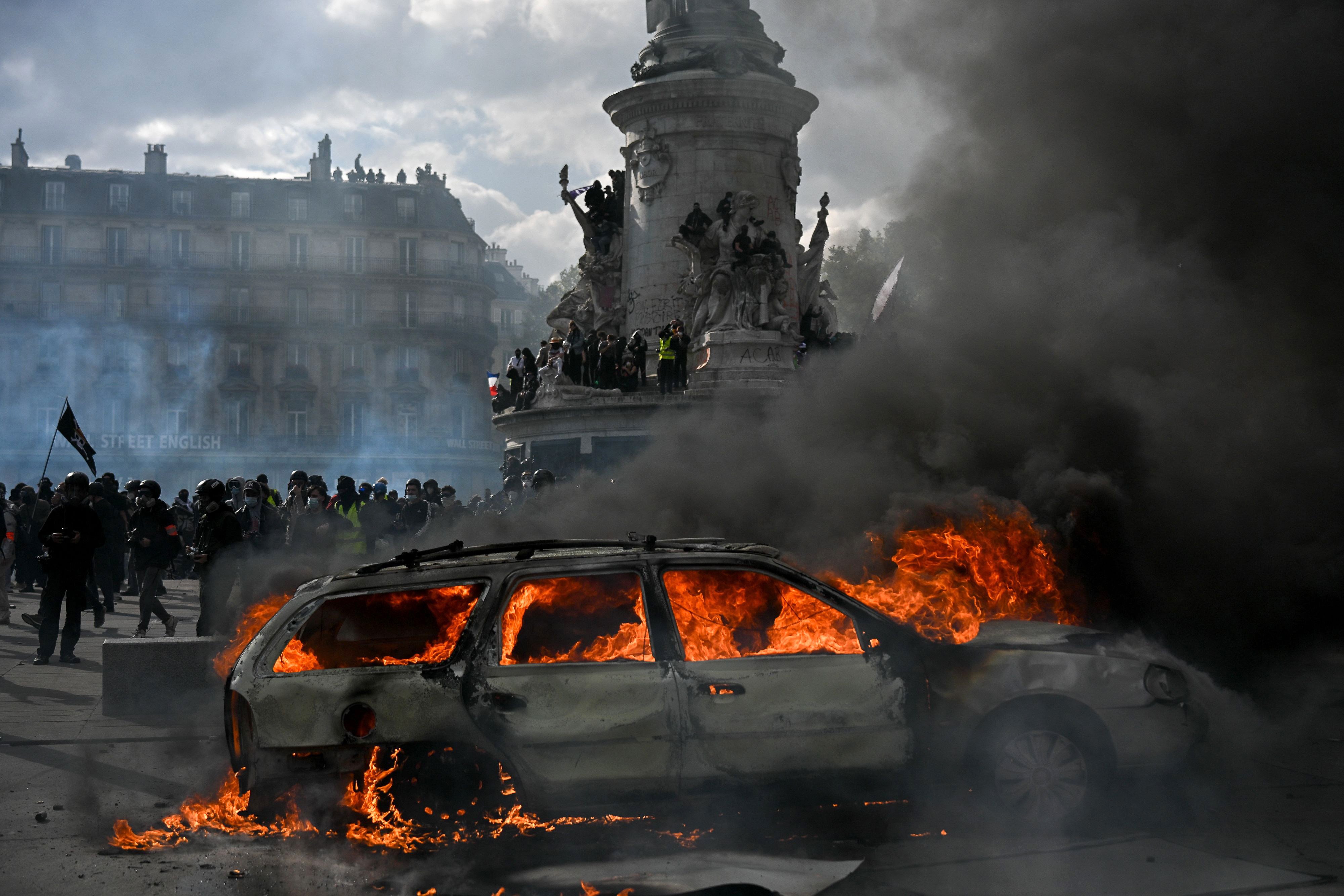 A car burns at Place de la Republique in Paris as clashes erupt between protesters and police on October 17. Photo: dpa