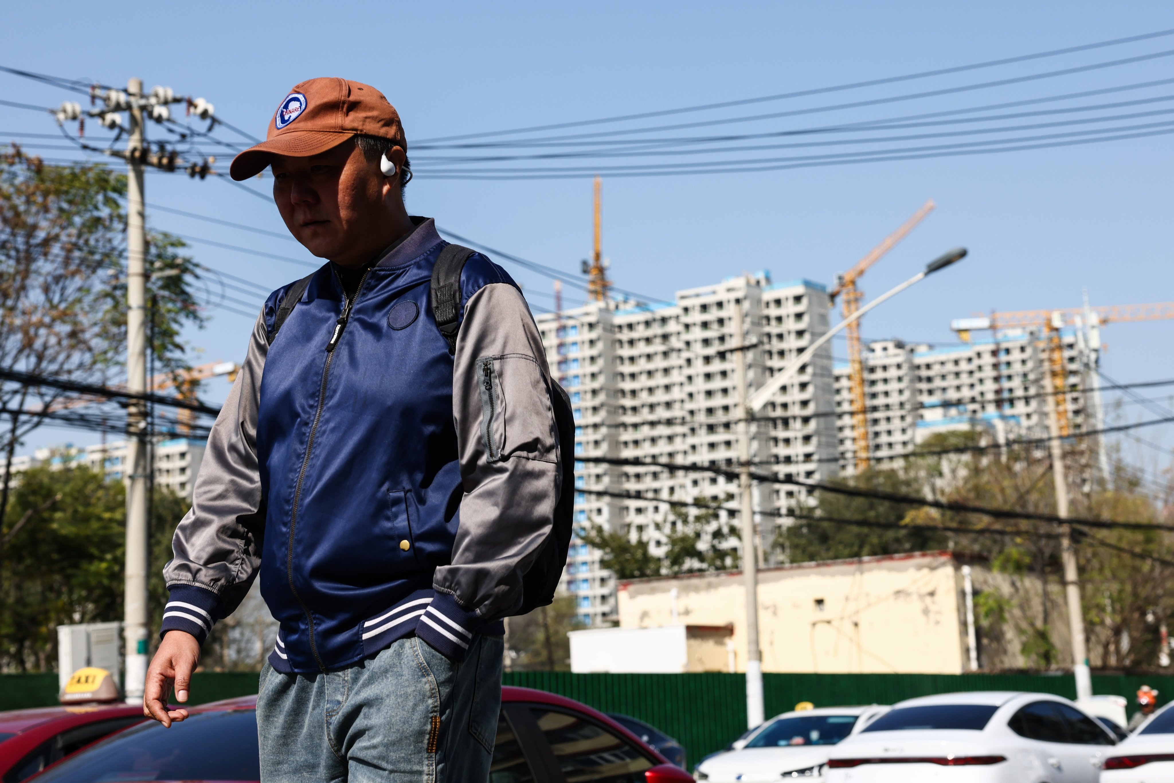 A man walks in front of a residential construction site in Beijing on Monday. Photo: EPA