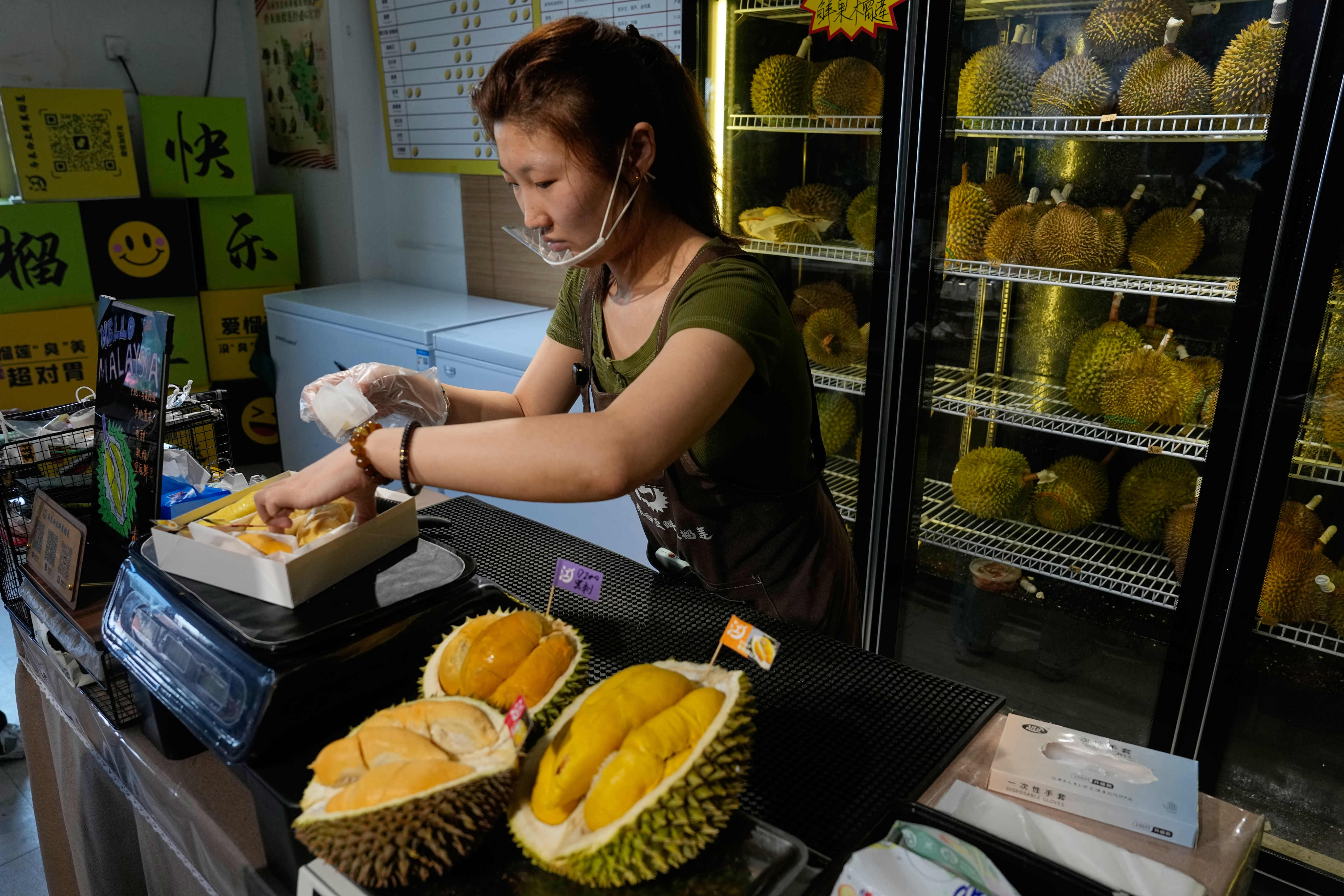 A worker packs durian imported from Malaysia to deliver to a customer at a shop in Beijing on July 13. Photo: AP
