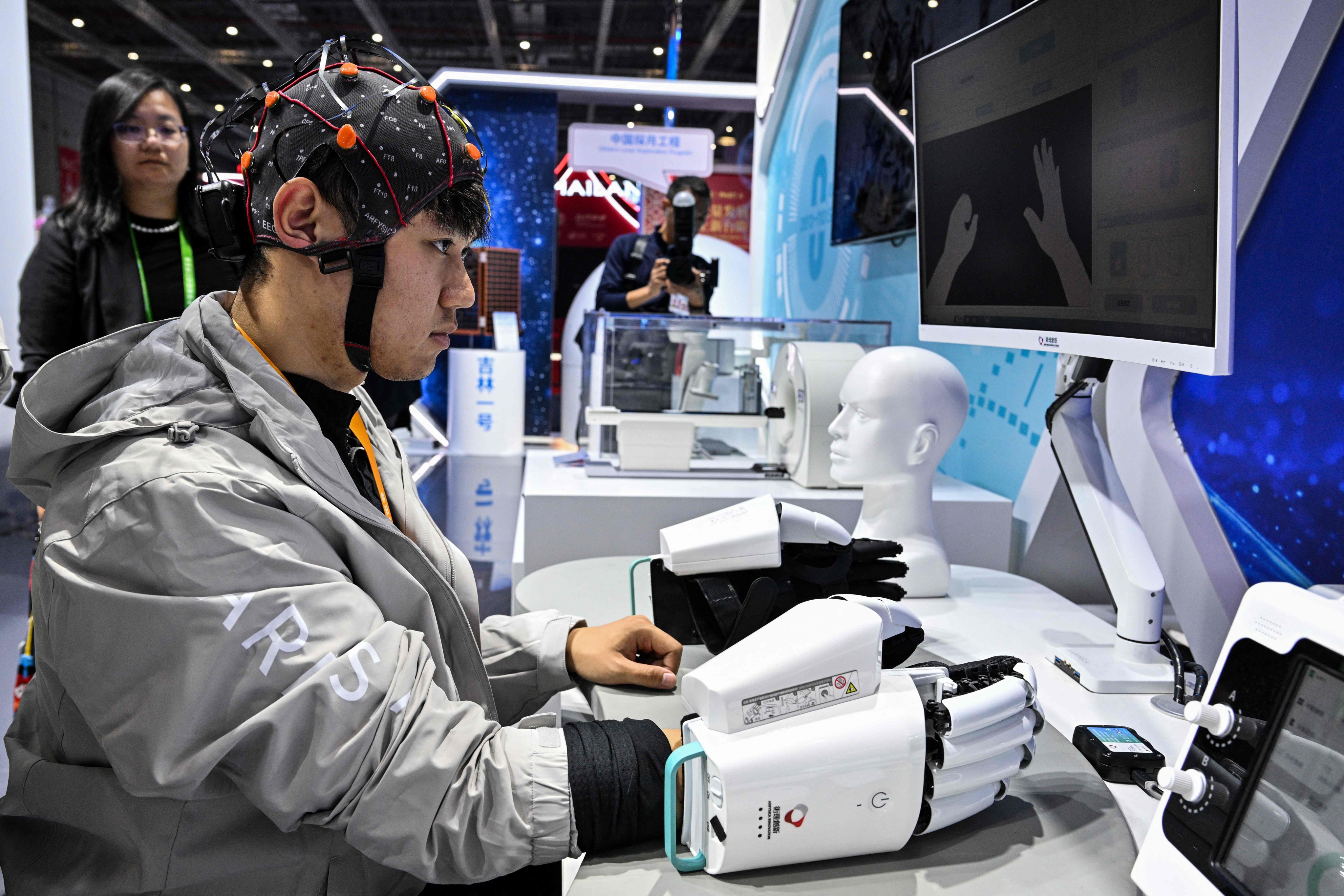 A man demonstrates a robotic hand with a brain-computer interface during the 8th China International Import Expo in Shanghai on November 7. Photo: AFP