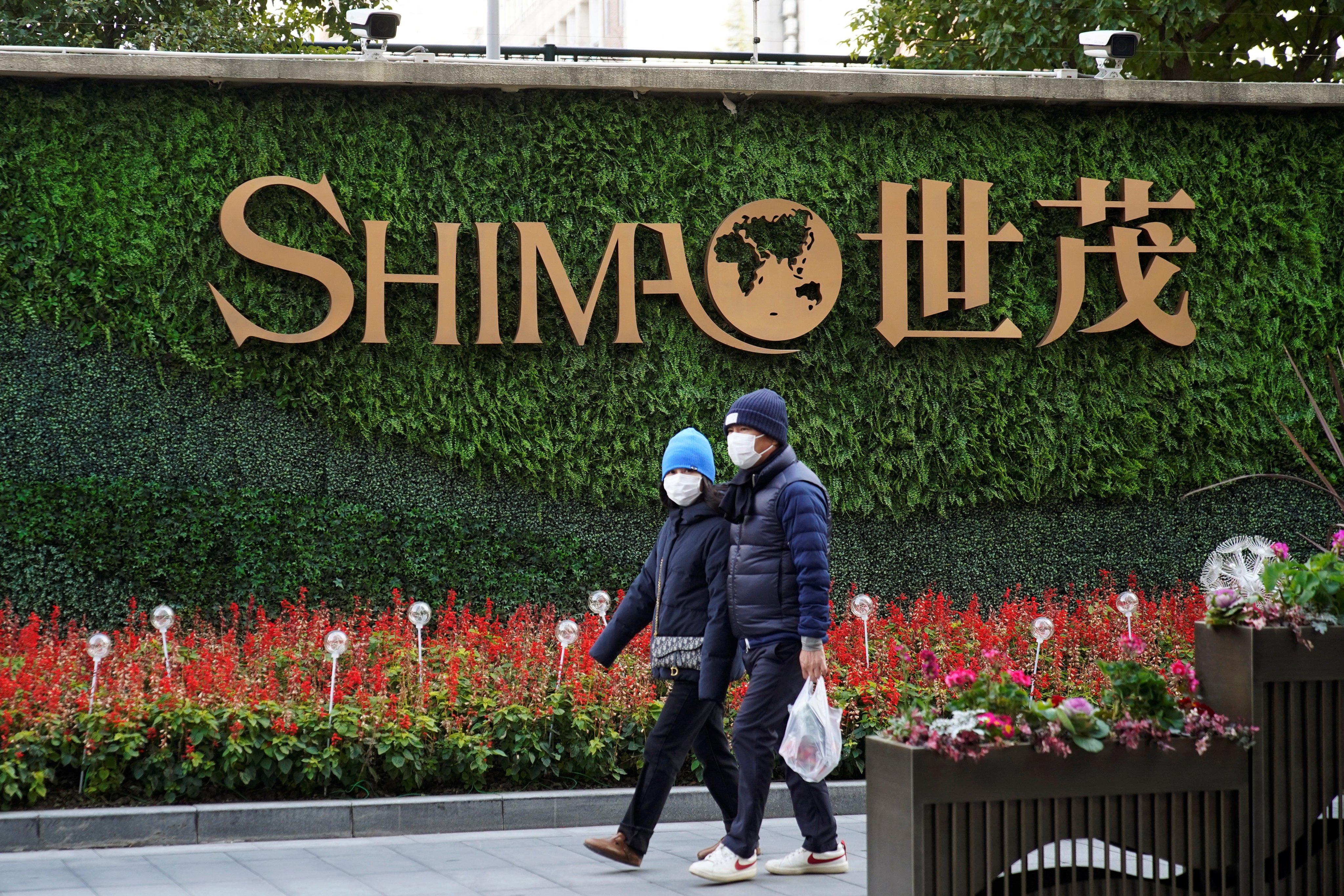 People walk past the logo of property developer Shimao Group near Shimao Tower in Shanghai. Photo: Reuters