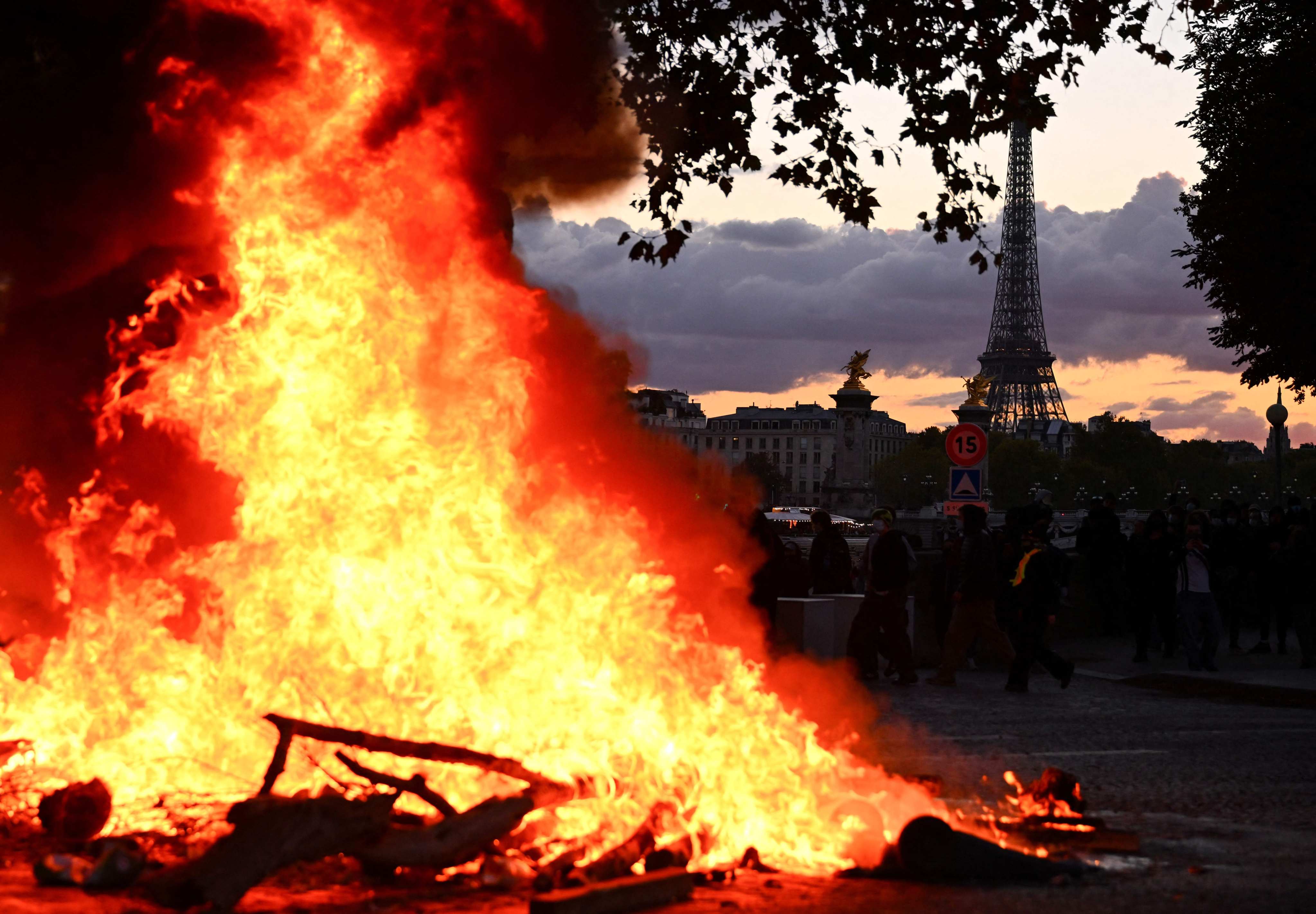 A fire is seen with the Eiffel Tower in the background during a demonstration in Paris on Saturday. Photo: AFP