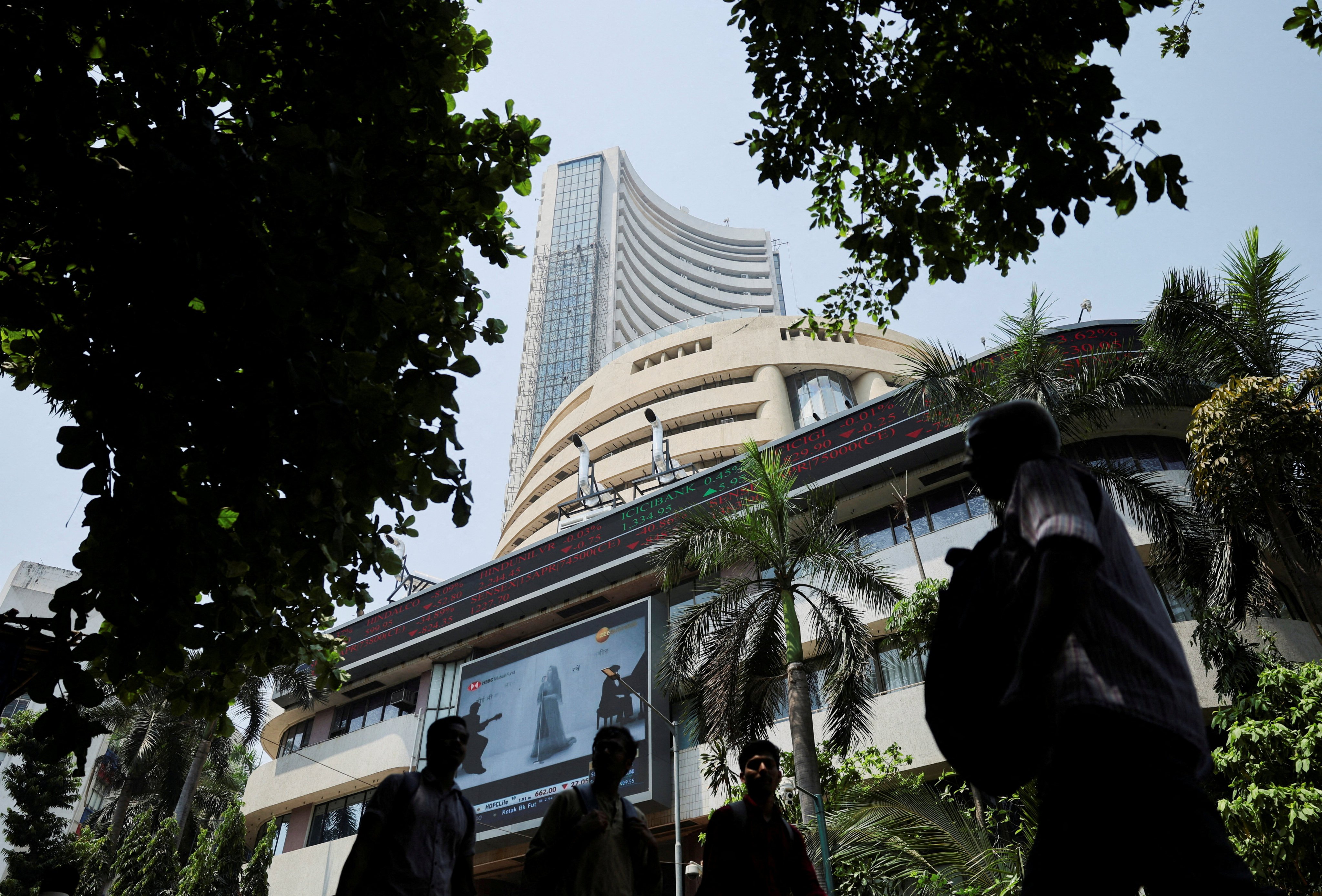 People walk past a screen displaying market results outside the Bombay Stock Exchange in Mumbai on April 7, 2025. Photo: Reuters