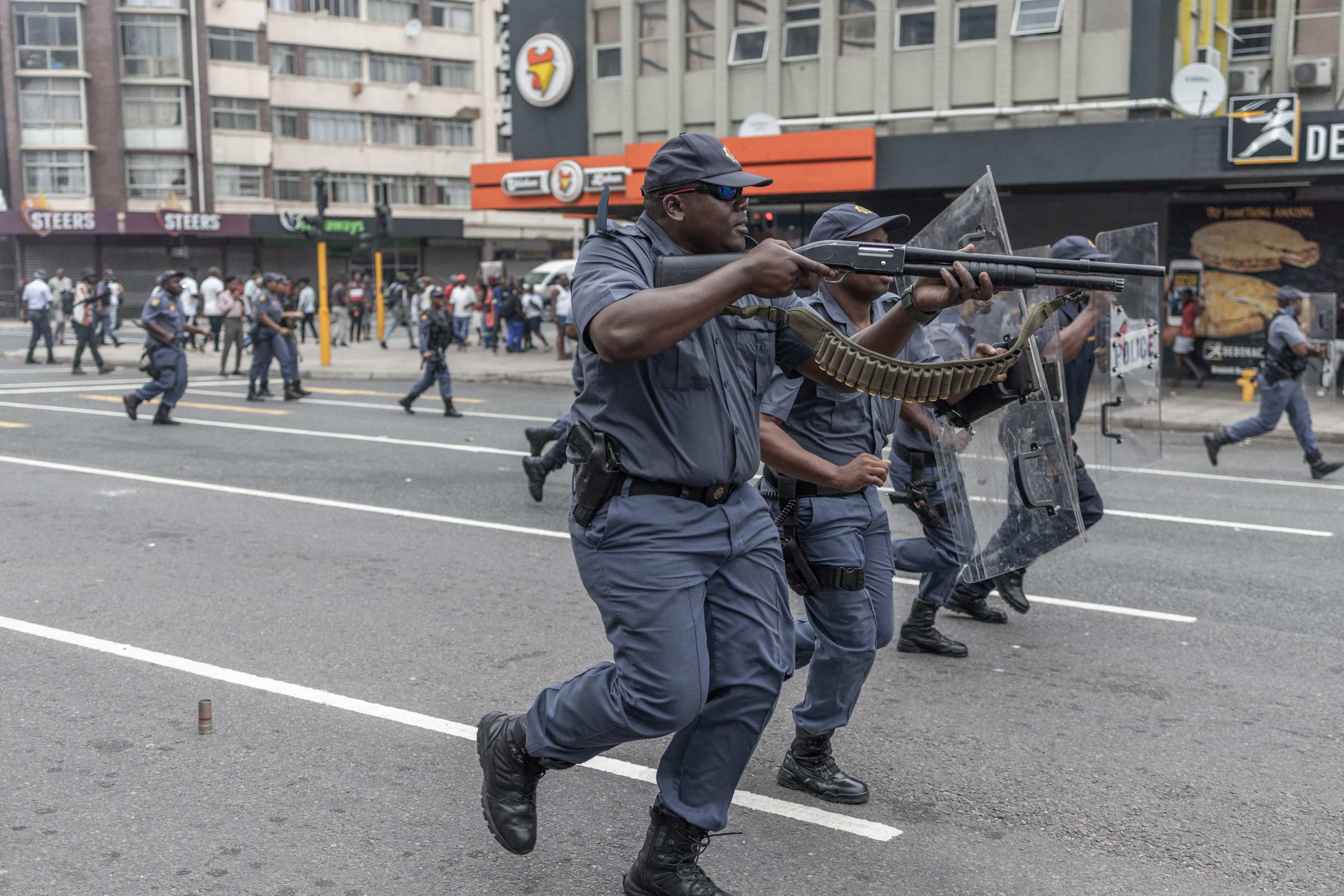 Members of the South African Police Service fire rubber bullets towards anti-migrant protesters during a march in Durban on October 9. Photo: AFP