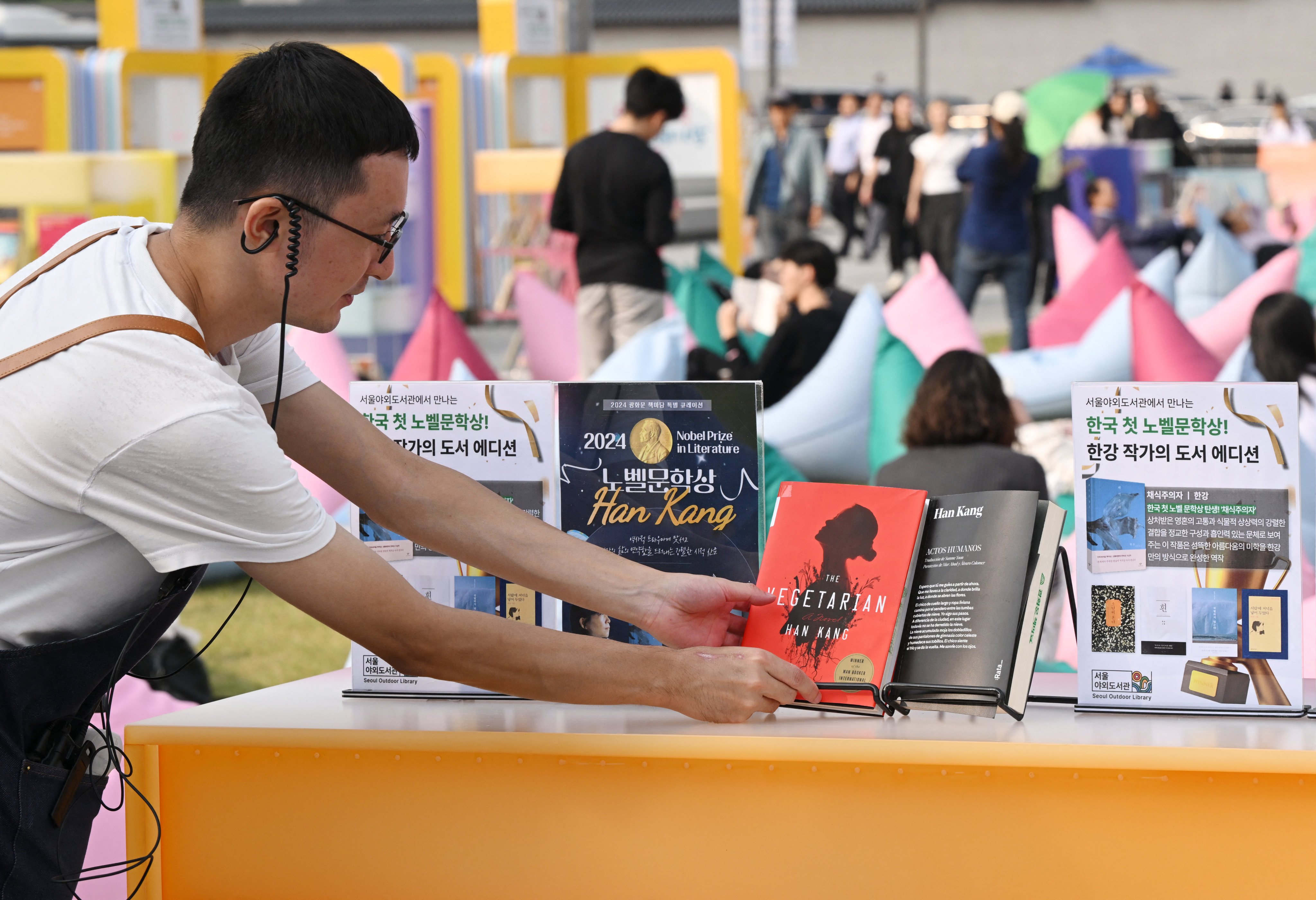 A staff member arranges books by South Korean author Han Kang at an outdoor library event at Gwanghwamun square in central Seoul on October 11, 2024. Photo: AFP
