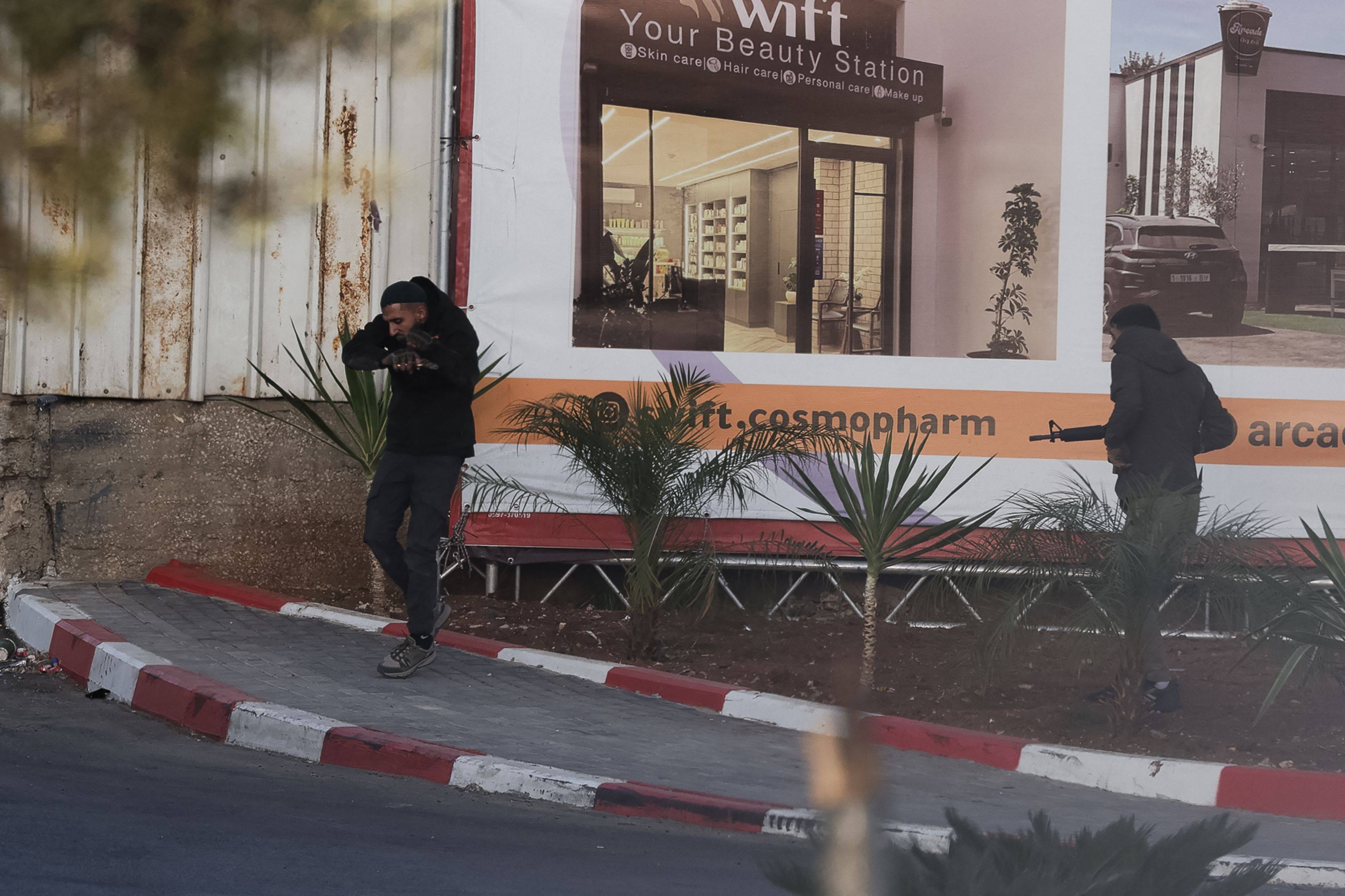 Armed Palestinian gunmen exchange fire with Israeli forces at a checkpoint near Hebron in the occupied West Bank on Friday. Photo: AFP