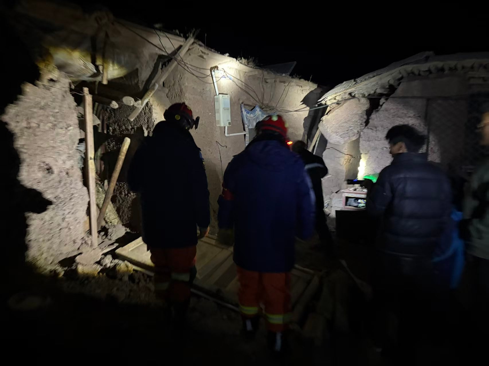 Firefighters inspect the damage to a village that was struck by the earthquak on Thursday night. Photo: Xinhua