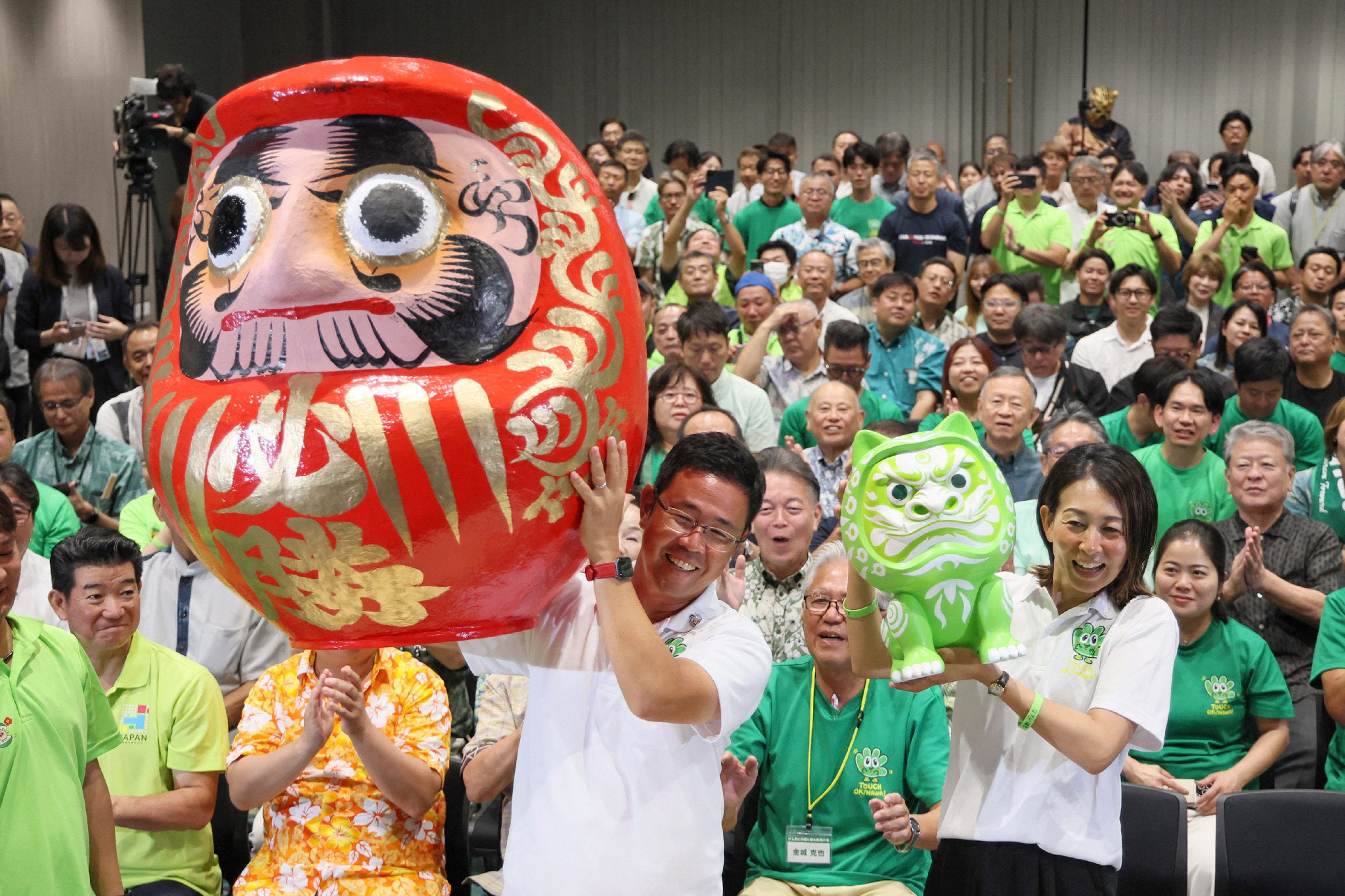 Genta Koja (centre) celebrates winning the Okinawa gubernatorial election in Naha on September 13. Photo: Jiji Press / AFP