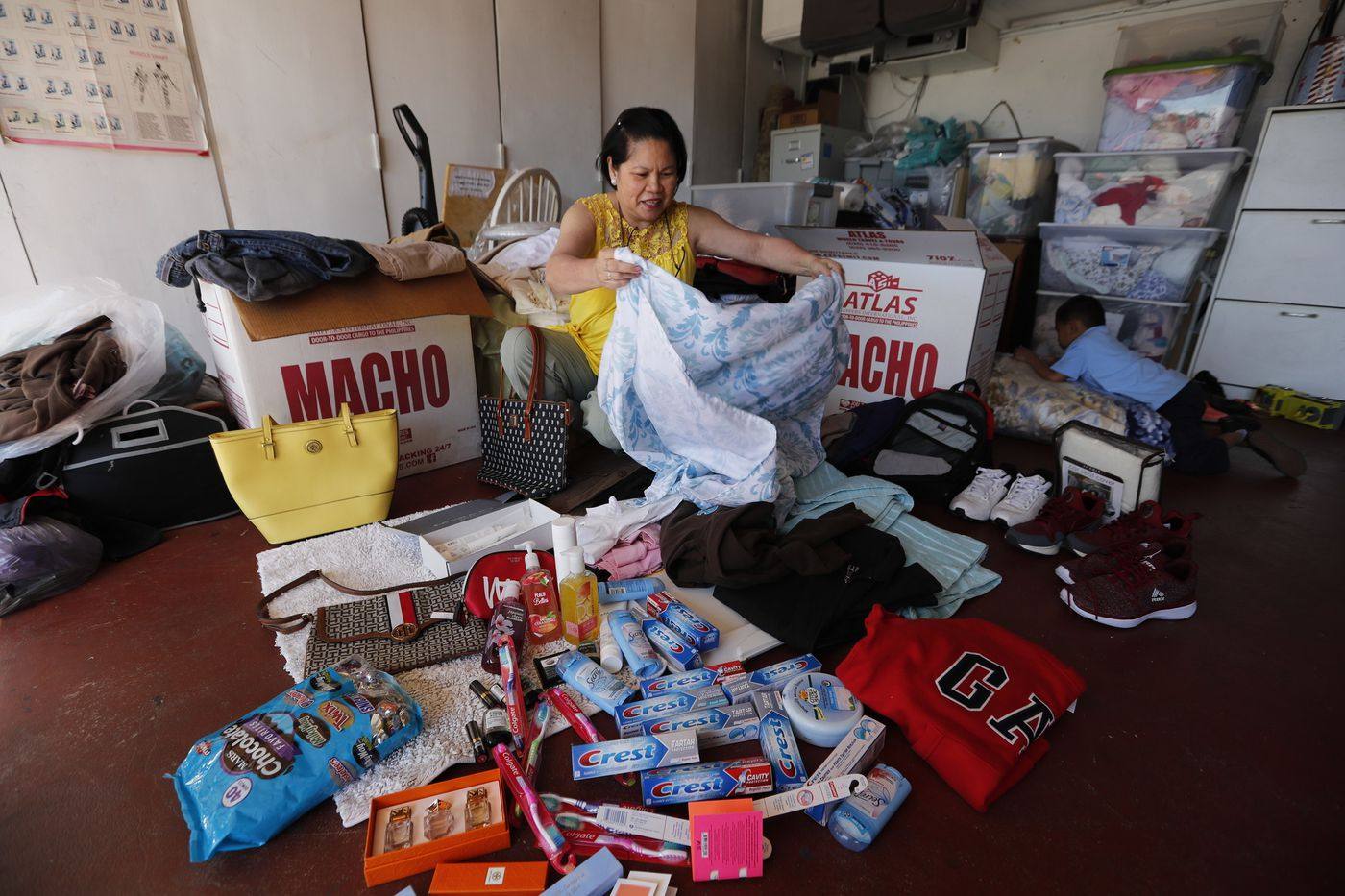 A Filipino packs balikbayan boxes at her home in Long Beach, California. Photo: Los Angeles Times