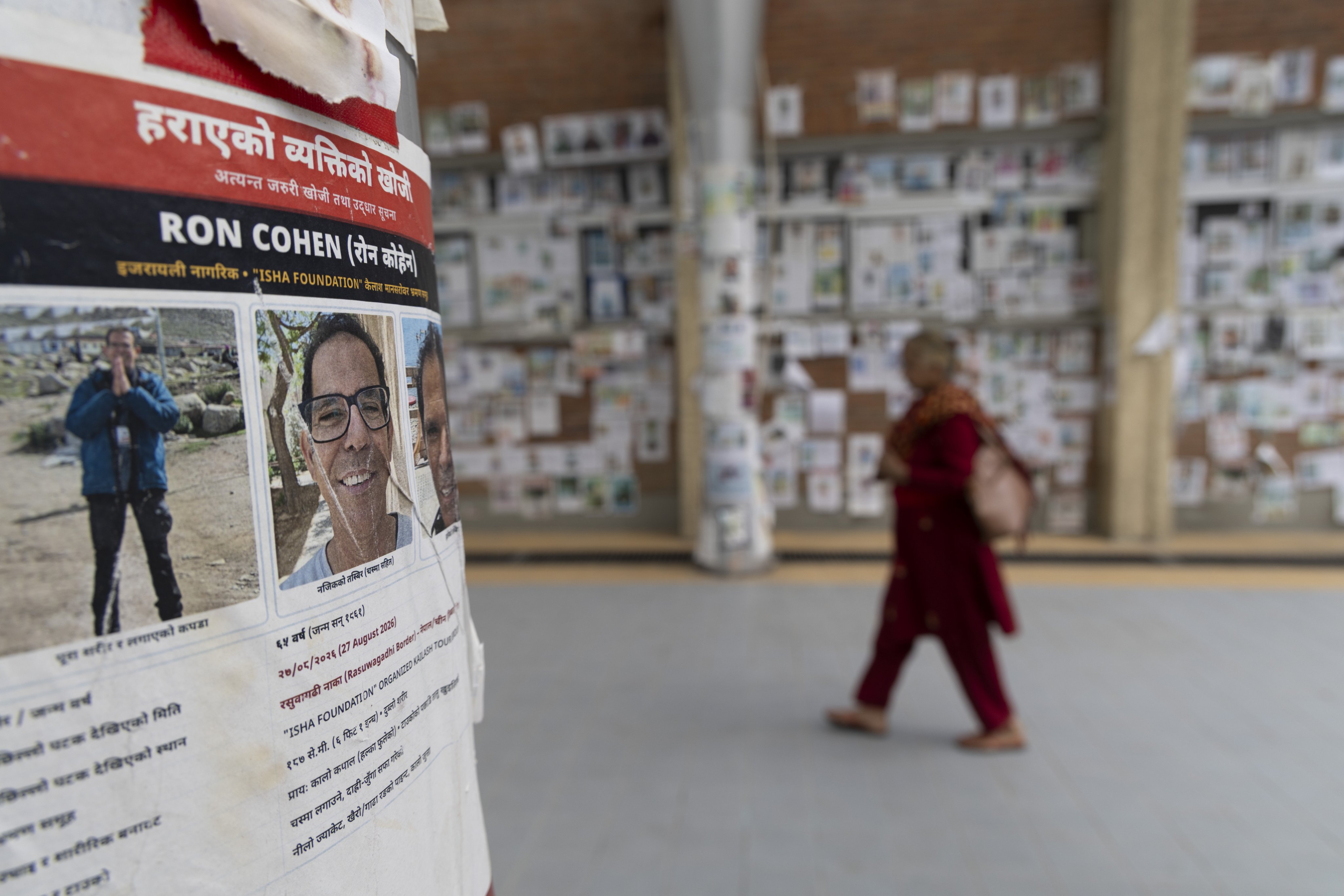 A woman walks past photographs of people who remain missing following the August flash floods, displayed in Kathmandu on October 7. Photo: EPA